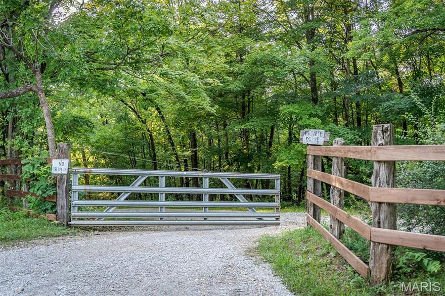 Located 45 minutes from St louis just outside of Robertsville MO is this private hideaway on 60+ acres!! This estate offers a "2-acre lake" and a 2nd pond! The sale includes a (40x100) 4000 sq ft metal outbuilding for RV storage, w/ 6" poured concrete floors, two 14' overhead garage doors w/openers for ease of drive through access. The 1300 sq ft detached 4 car garage has electric, water, and a lofted second floor storage area.   Included in this package is the very stately stone chalet style home to reside in and offers 2600+ sq ft. of modern amenities.  The main residence was built around the 1930's.  It includes 2 beautiful stone fireplaces,  exposed log walls and a cathedral ceiling.  A Hand carved log-built handrail  is attached to the staircase and leads to 2 spacious bedrooms upstairs.  The primary suite is located on the main floor and  is  vast enough for a "sitting", place, his/her closets and a full ensuite accommodating a soaking tub and separate shower.  For larger entertainment the cook will enjoy a scullery (dirty kitchen) and a main kitchen w/many cabinets, counters and appliances. Laundry is off the kitchen on the main level and another room offers a nice view from what could be an office/library or green room. The roof is brand new in 2025 and the basement is clean and well maintained with 220 electric and a canning kitchen.  All you have wanted is waiting right here!  Make your offer today.