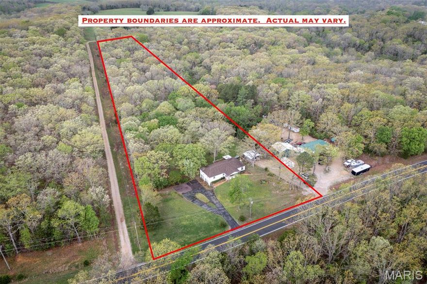 First showing Saturday, April 18th. Opportunity knocks on acreage! This property offers incredible sweat equity potential for the buyer ready to make it their own, all set on gorgeous land featuring cleared, level front and back yard space surrounded by wooded privacy. A 2-car tuck-under garage, 2-car carport, shed, and barn offer tremendous storage and utility, while the U-shaped drive makes entertaining and turnarounds a breeze. Entertain in style with a family and dining room combination highlighted by a stone wall, and a breakfast room with butler's pantry that flows seamlessly onto the large, partly covered deck — perfect for morning coffee or evening gatherings. The kitchen already boasts ample space for a future island, while laminate wood-look flooring adds warmth throughout the main level living areas. The primary suite is truly impressive in size, featuring dual ceiling fans and a private bath with shower and linen closet. Secondary bedrooms are exceptionally spacious, and the hall bath impresses with a dual-sink vanity and glass door shower. Main floor laundry adds everyday convenience. A full walk-out lower level complete with kitchen and half bath provides a blank canvas ready to be finished to your vision. Major updates include a roof (approx. 9 years) and HVAC (2015). Come see the potential — this one has it all!