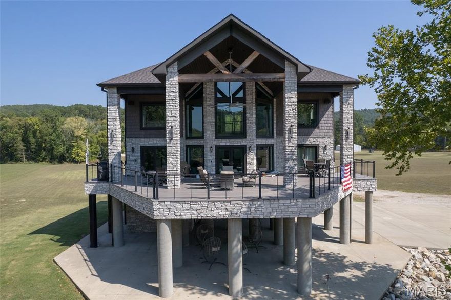 Welcome to your private sanctuary on the banks of the beautiful Current River—where contemporary elegance meets natural serenity. This architecturally striking custom cabin blends stone, timber, and glass to create a commanding presence, elevated on concrete piers for panoramic views and secure riverfront living.
Step inside to soaring cathedral ceilings, floor-to-ceiling windows, and an open-concept design that floods the interior with natural light. The grand living space features a massive stacked-stone fireplace, designer finishes, and seamless flow into a modern kitchen and dining area, perfect for entertaining.
Wake up every day to river views, and enjoy outdoor living at its finest on the expansive wraparound deck—ideal for gatherings, morning coffee, or fireside evenings under the stars.
Situated on over 3.77 acres more or less with direct access to the river, this one-of-a-kind property offers the ultimate escape—whether you’re looking for a full-time residence, luxurious vacation home, or high-end rental investment.