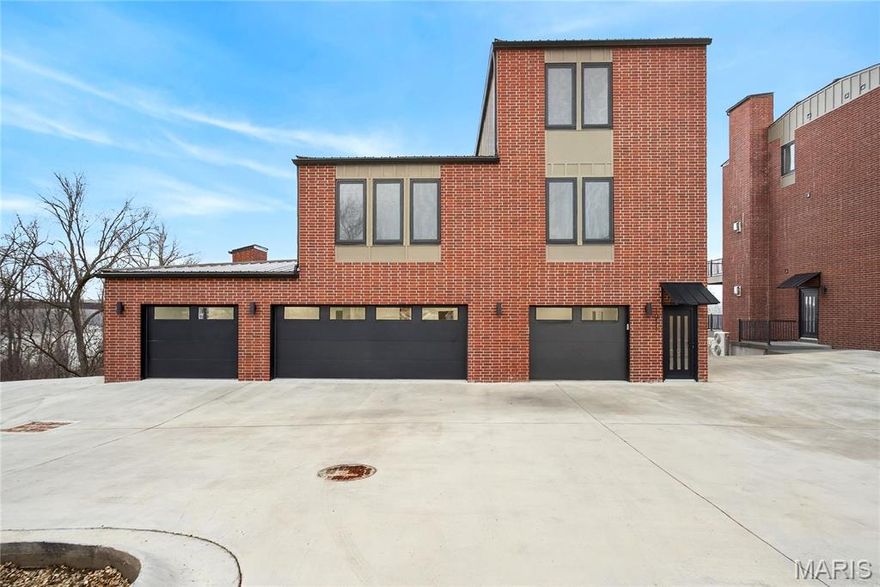 Perched high above the Missouri River with exquisite, panoramic views, this custom-built residence at The Bluffs at Bassora Place delivers a rare fusion of contemporary design, modern luxury & master-level craftsmanship. Offering 4,112 sq ft of refined living space, two expansive maintenance-free decks totaling 972 sq ft, & an impressive 1,194 sq ft 4-car garage, this home is purpose-built for elevated living. Step inside to discover beautiful hardwood floors, a welcoming ceramic-tiled entry & a designer kitchen featuring custom marble countertops, bespoke cabinetry & premium finishes throughout. Imported German-engineered windows & doors frame the river’s ever-changing scenery while enhancing energy efficiency & architectural sophistication. Two fireplaces add warmth & ambiance across the main and upper levels. The fully finished walkout lower level includes a full bathroom & flexible living space ideal for guests, recreation, or a private retreat. Two spacious, light-filled bedrooms occupy the second floor, each designed with comfort & style in mind. The entire third floor is dedicated to the primary suite, creating a private sanctuary with sweeping river vistas. The en-suite bathroom showcases a custom tile shower, granite countertops, a soaking tub & radiant heated floors. Dual custom closets complete the suite, offering exceptional storage & thoughtful organization. A 4-stop elevator provides effortless access to every level, ensuring convenience without compromise. The Bluffs at Bassora Place offers two additional townhome floor plans, but for those seeking more space, more luxury & more dramatic views, this custom design can be built for you as well—a rare opportunity to personalize a home of this caliber in one of Washington’s most breathtaking settings.