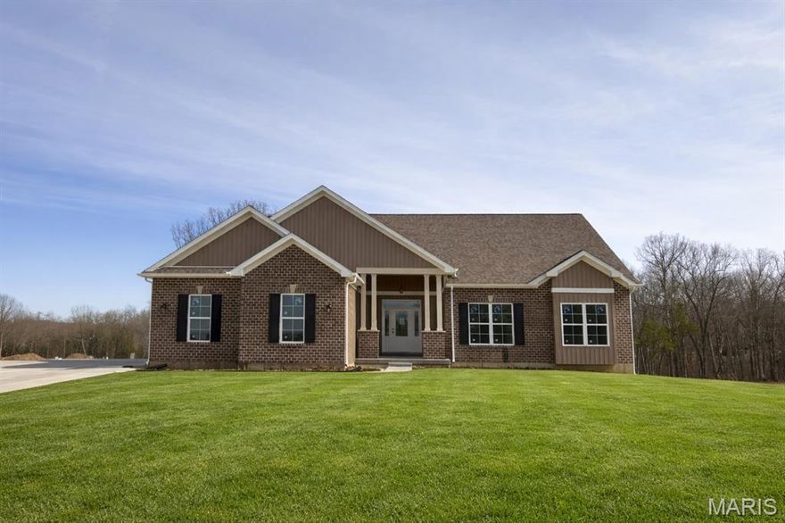 Now Under Roof – Move-In Ready in the New Year! Why settle for less when you can have it all? The Sycamore Model at The Estates at Schaper Farms is currently under construction and offers the ideal blend of space, quality, and setting on a 3.05-acre walk-out lot in the sought-after Wentzville School District. This thoughtfully designed 3 bedroom, 2 bath ranch features 2,097 sq ft of open-concept living with upscale finishes throughout.
The exterior showcases a striking brick and board-and-batten facade with a side-entry oversized 3-car garage (30’ x 24’). Inside, enjoy 10-foot ceilings, 8-foot doors, and transom windows along the back that fill the home with natural light. The kitchen is designed for both function and style, offering 42” staggered cabinets, quartz countertops, a large island, walk-in pantry, soft-close doors, dovetail drawers, and stainless steel appliances including a double oven, ceramic cooktop, cabinet hood, and microwave drawer. LVP flooring runs throughout the main living areas with ceramic tile in the baths.
The private primary suite features dual vanities, a soaking tub, and a walk-in shower. The walk-out lower level includes a slider to the patio, providing easy backyard access and flexibility for future finish or outdoor living. The list price reflects approximately $10,000 off the builder’s base price, resulting in added value and upgraded features at no additional cost to the buyer. Exceptional quality, generous acreage, and a serene setting—this home truly delivers. Dare to compare.