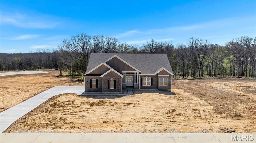 Now Under Roof – Move-In Ready in the New Year! Why settle for less when you can have it all? The Sycamore Model at The Estates at Schaper Farms is currently under construction and offers the ideal blend of space, quality, and setting on a 3.05-acre walk-out lot in the sought-after Wentzville School District. This thoughtfully designed 3 bedroom, 2 bath ranch features 2,097 sq ft of open-concept living with upscale finishes throughout.
The exterior showcases a striking brick and board-and-batten facade with a side-entry oversized 3-car garage (30’ x 24’). Inside, enjoy 10-foot ceilings, 8-foot doors, and transom windows along the back that fill the home with natural light. The kitchen is designed for both function and style, offering 42” staggered cabinets, quartz countertops, a large island, walk-in pantry, soft-close doors, dovetail drawers, and stainless steel appliances including a double oven, ceramic cooktop, cabinet hood, and microwave drawer. LVP flooring runs throughout the main living areas with ceramic tile in the baths.
The private primary suite features dual vanities, a soaking tub, and a walk-in shower. The walk-out lower level includes a slider to the patio, providing easy backyard access and flexibility for future finish or outdoor living. The list price reflects approximately $10,000 off the builder’s base price, resulting in added value and upgraded features at no additional cost to the buyer. Exceptional quality, generous acreage, and a serene setting—this home truly delivers. Dare to compare.