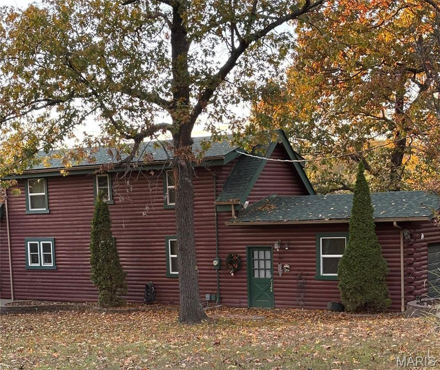 This Charming personalized rustic log cabin offers the perfect blend of warmth and character. Relax on the covered back porch overlooking the fenced in back yard-ideal for morning coffee or peaceful evenings surrounded by nature. Inside you will find a cozy 3-bedroom, 2-bathroom home featuring a stunning accent fireplace that efficiently heats the space and creates the perfect cabin ambiance. The open-concept kitchen flows into a comfortable family sitting room, making it   great for entertaining or quiet nights in. A full basement with outdoor access adds extra storage or potential living space. Don't miss the chance to make this inviting log cabin your home or weekend retreat in a scenic lake community.