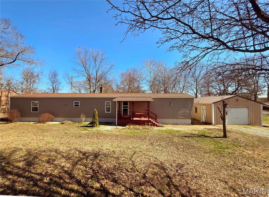 Best of both worlds- Close to town but privately located in county! Modern 3 bedroom, 2 full bath manufactured home, included an enclosed back porch for more livable space and with detached garage/workshop and carport. Well maintained. A/C unit & roof only 3 years old. Living room has electric fireplace. Kitchen appliances, washer & dryer stay. Updated back deck to take in country views. Also has a storm cellar that has a sump pit and wood stove that heats whole home. Nicely manicured and landscaped. Situated on just a little under an acre. Exceptional value- call today!