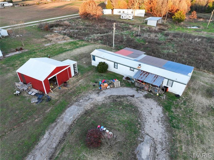 Updated 4-bedroom, 3-bath home located on the east front of the property, featuring a 24x24 shop suitable for storage or equipment. The home combines original character with modern updates, including real wood flooring in the living room and a wood stove. The kitchen, hall, laundry room, and bathrooms include tile flooring, and knotty pine walls run throughout the home. A 12x40 addition provides a dining area, two additional bedrooms, and a bathroom, bringing the total to 4 bedrooms, 3 bathrooms, a dedicated laundry room, kitchen, and living room. This property offers ample space and a functional layout for a variety of needs.