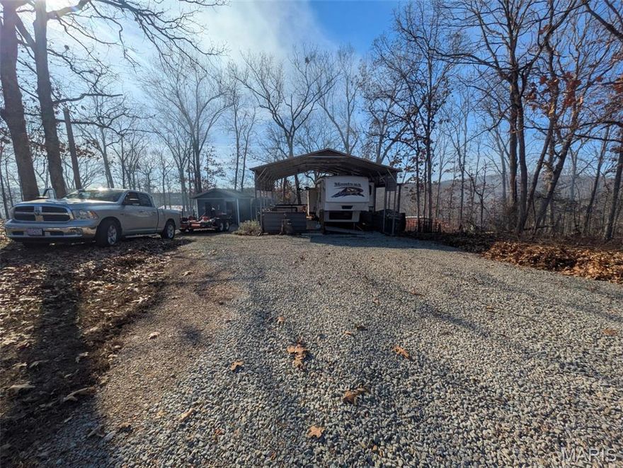 Looking forward to warmer weather and outdoor activities? Welcome to this well-maintained double lot in the gated Goose Creek community. This property is fully set up for immediate use and offers an excellent foundation for a weekend retreat or future lake home.

The property features a 34' camper in excellent condition, offering a king-sized bedroom, full kitchen/living area, real wood flooring, and a built-in vacuum system. The camper is secured on rock and concrete bracing, providing increased stability and longevity.  A large carport covers the camper and provides a 35'x12' seating area with two outdoor, mounted fans.

Additional improvements include a sewage holding tank, a fire pit, a utility shed for storing tools, and a separate laundry room (washer, dryer, and refrigerator included) for added convenience—an uncommon and valuable feature in lake properties.

With two lots, there is ample room for outdoor seating areas, parking, or future building plans. Enjoy all the amenities Goose Creek offers, including gated access, boating, fishing, swimming, and community recreation areas.  There are also electric hook ups for additional campers on the secondary lot should you want to host friends. 

Get ready to enjoy the lake life! Schedule your showing today.