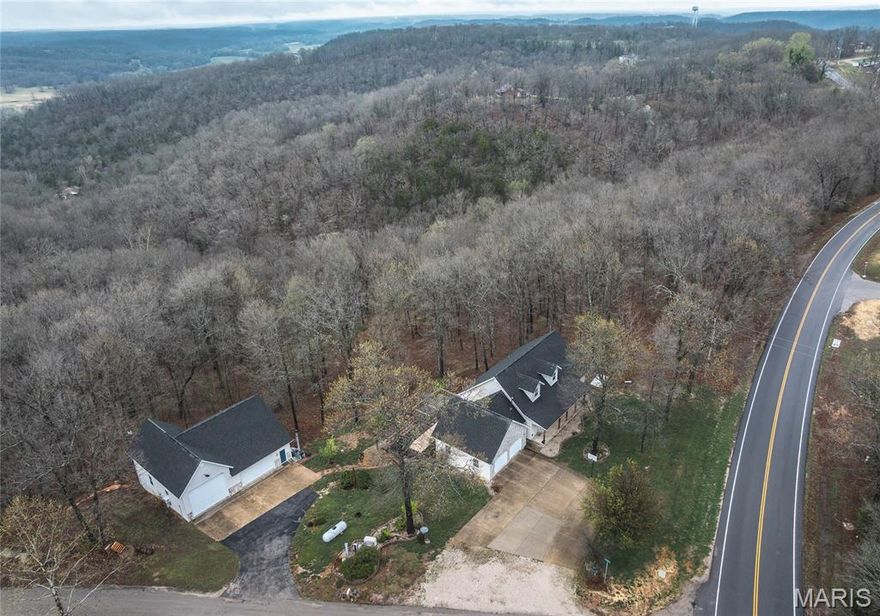 This beautiful, one-of-a-kind property truly has it all—offering space, functionality, and incredible indoor and outdoor features. With 5 bedrooms and 3 bathrooms, this home provides plenty of room for families, guests, or multi-generational living. Inside, you’ll find a thoughtfully designed layout featuring a stunning kitchen with stainless steel appliances, a bright living room with a bay window, and a versatile loft area that’s perfect for a home office, reading nook, or additional living space. The spacious primary suite is a true retreat, complete with tray ceilings and a luxurious ensuite bathroom featuring a jacuzzi tub and separate shower. The fully finished walkout basement adds even more living and entertaining space, with French doors leading outside and a projector that has never been used—ideal for creating your own home theater or game room. Step outside and take in the peaceful, scenic setting. The property features a beautifully designed 2,400-gallon koi pond, a multi-level deck perfect for entertaining, and a hot tub for relaxing evenings under the stars. Nature lovers will appreciate the private trails, ravine, and spring-fed feature that add to the property’s charm and usability. A standout feature is the detached 3-car shop, offering incredible versatility. It includes a lift, half bath, 30-gallon water heater, separate septic system, pellet and wood stove, and its own air handling system—making it ideal for a workshop, hobby space, or additional storage. A survey is included for added convenience and peace of mind. From the thoughtfully designed interior to the impressive outdoor amenities, this property offers a rare opportunity to enjoy comfort, privacy, and functionality all in one exceptional package.