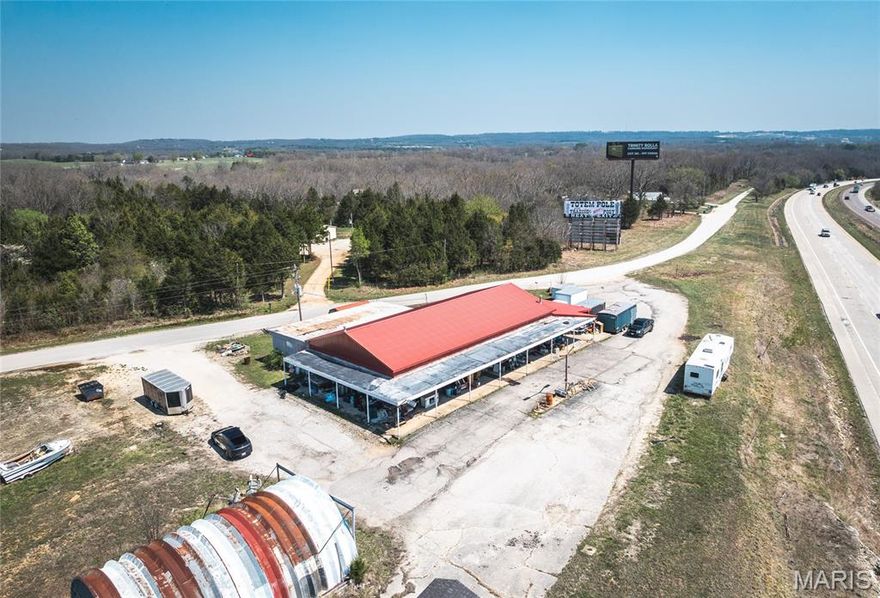 A versatile mixed-use commercial opportunity situated on 3.39 acres m/l with approximately 659 feet of high-visibility frontage along I-44. The main building offers 4,300 square feet and has long served as the home of a successful auction service business. It features central heating and cooling, two restrooms, a kitchenette, covered storage, and a dedicated back stockroom area—well-suited for a variety of commercial operations. Additional improvements include a 1,120 square foot quonset hut with large front double doors and rear access, providing excellent space for equipment, inventory, or workshop use. A separate storage shed along CR 8140 with a durable metal roof adds even more functionality. The property also includes a well-maintained residential home built in 2012, offering 3 bedrooms and 2 baths. The home is all-electric and currently tenant-occupied, creating an immediate income stream. Served by a private well and lagoon system, this property presents a unique combination of commercial capability and residential income. With outstanding interstate exposure and ample space for expansion, this is an ideal investment for business growth. Priced to sell—don’t miss this opportunity.