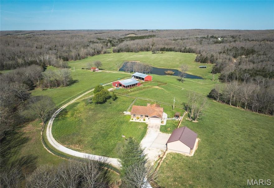 Welcome to this beautiful, well-maintained home and picturesque 126 +/- acre farm offering stunning views and peaceful country living. A gated entry and private driveway lead you into this serene property featuring a perfect mix of pasture and wooded acreage. This remarkable property showcases a stunning blend of open pasture, woods, and exceptional water features, including a picturesque 3.5 acre lake, six peaceful ponds, and wet weather creek through the valley. Designed for both recreation and relaxation, the land invites ground for cattle, horseback riding, trail adventures, fishing, hunting, hiking, or quiet evenings surrounded by natural beauty. The home offers 3 bedrooms plus one nonconforming bedroom and 3.5 bathrooms, combining solid construction with warm rustic charm. Interior highlights include a stone fireplace with Heatilator, granite countertops and island, custom cabinetry, walk-in closet(s), newer flooring, and an open floor plan designed for comfortable living and entertaining. The full walkout basement features a kitchenette, sleeping area, full bathroom, and ample storage space. A geothermal HVAC system provides efficient year-round comfort. Enjoy breathtaking views from the covered back deck, newer lower deck, or the newer patio with pergola. The property also includes an attached garage and a large, detached 3+ vehicle garage/workshop. Equestrian and farm amenities abound with a large 8 stall barn, a spacious hay and equipment barn, and a run-in shed located within the pasture.  Overlooking the lake, an additional charming 744 sq ft guest cabin offers its own kitchen area, sleeping quarters, and bathroom, creating an ideal space for guests, private retreats, or unforgettable gatherings. Numerous updates have been completed throughout the property (see supplements for details). Whether you’re seeking a full-time residence, working farm, or recreational retreat, this serene and versatile property delivers the ideal country lifestyle. Conveniently located just south of Owensville and Rosebud. Schedule your private tour and experience the essence of country living!