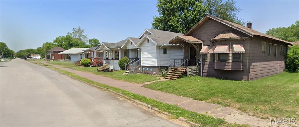 Bungalow with a front yard, a residential view, and a chimney