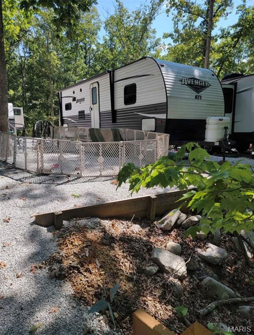 Secluded, maintenance-free lot at Dogwood Lake Campground with a brand-new walking bridge to private parking. Includes a like-new 2019 24 ft camper with slide-out, primary bedroom, oversized bath, and eat-in kitchen with stove, microwave, and refrigerator. Year-round water, 1,000-gallon city-inspected holding tank, 50-amp service, marine-grade battery, two TVs, and new couch. Enjoy campground amenities including clubhouse, updated pool, three renovated bathhouses, playground, community events, and access to the main lake for fishing, swimming, and trolling-motor boating.