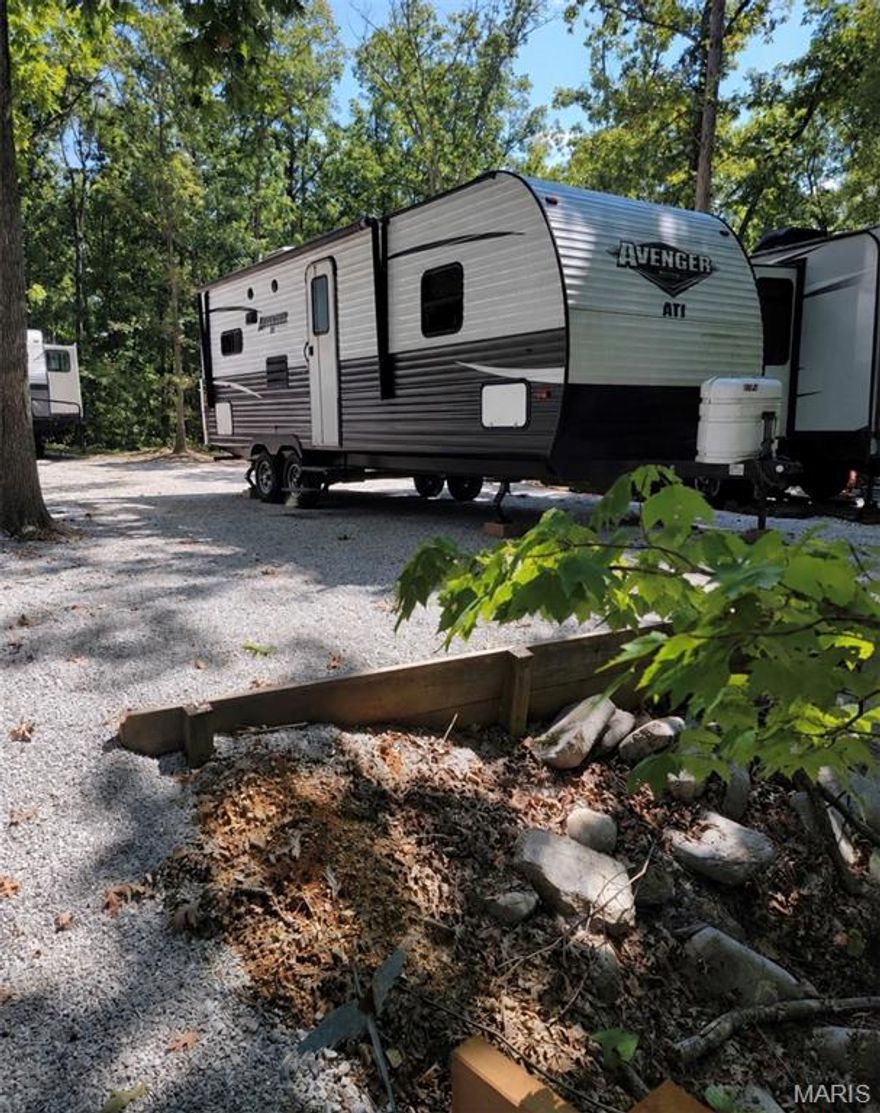 Secluded, maintenance-free lot at Dogwood Lake Campground with a brand-new walking bridge to private parking. Includes a like-new 2019 24 ft camper with slide-out, primary bedroom, oversized bath, and eat-in kitchen with stove, microwave, and refrigerator. Year-round water, 1,000-gallon city-inspected holding tank, 50-amp service, marine-grade battery, two TVs, and new couch. Enjoy campground amenities including clubhouse, updated pool, three renovated bathhouses, playground, community events, and access to the main lake for fishing, swimming, and trolling-motor boating.