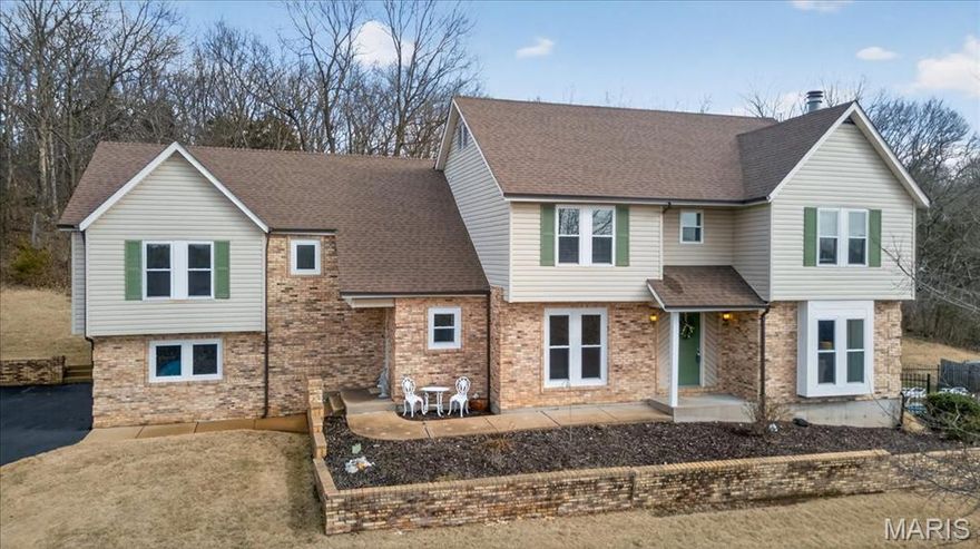 Beautiful 2-story home set on a breathtaking 5.25-acre lot backing to trees and overlooking a peaceful lake, complete with a private in-ground pool, your own secluded retreat! Perfectly positioned in a highly desirable location with easy access to neighboring towns of Wildwood and Eureka, you’ll enjoy the best of both worlds. Privacy and space with convenient access to shopping, dining, parks, and everyday amenities. Step inside to find a warm and inviting living room with a wood-burning fireplace and glass French doors leading to a private office. A formal dining room is accented by wood floors. The gorgeous kitchen offers granite countertops, a planning desk, wall oven, an electric cooktop, and a pass-through breakfast bar that opens to the vaulted family room with a second wood-burning fireplace and patio access, perfect for entertaining or relaxing while taking in the views. A mud room and powder room complete the main level. Upstairs, the sprawling primary suite showcases wood floors, two walk-in closets, private patio access, and a luxurious ensuite bath with double sinks, a walk-in shower, and a jetted tub. Three additional bedrooms, a full bath, and a laundry room complete the upper level. The walk-out lower level provides exceptional flexibility with its own private living quarters featuring a family room, full kitchen with solid surface counters and stainless steel appliances, a bedroom, a full bath, and additional laundry hook-ups. This versatile space is perfect for multi-generational living, older children, extended guests, or effortless entertaining. Additional highlights include an oversized 2-car garage, a newer roof, newer windows, newer carpet, and so much more. A rare opportunity to enjoy acreage, water views, and an unbeatable central location!