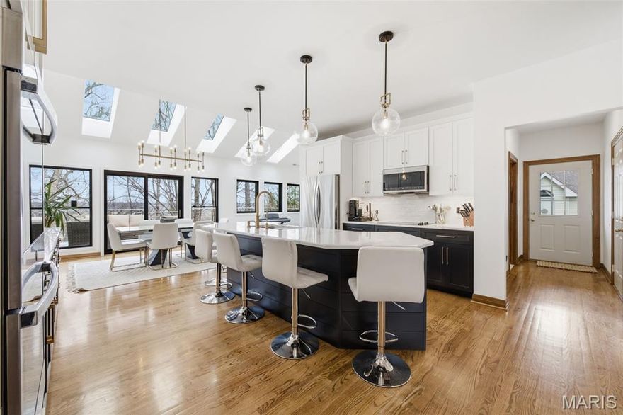 A TRUE SHOWSTOPPER in every sense, this extraordinary ranch in River Hills has been completely elevated w/ designer-level finishes, breathtaking architecture, & jaw-dropping updates that rival luxury new construction! From the moment you arrive, the circular driveway and dramatic black iron double front doors create an unforgettable first impression, setting the tone for the stunning spaces that unfold inside. Step into the dramatic two-story foyer where genuine hardwood flooring & a striking custom hand-cut wood slat accent wall immediately command attention, beautifully illuminated by hardwired sconces that highlight the craftsmanship & architectural design. The home then opens into a SPECTACULAR family room featuring soaring 15-FT coffered ceilings, rich hardwood floors, recessed lighting, and dramatic floor-to-ceiling shiplap gas fireplace that anchors the space, while an incredible wall of windows pours natural light into the room and showcases breathtaking wooded views behind the home. The kitchen is an absolute SHOWPIECE & truly the heart of the home, featuring luxurious quartz countertops, gorgeous cabinetry w/ crown molding and under-cabinet lighting, oversized brass hardware, & a massive shiplap-wrapped center island that comfortably seats SIX—perfect for entertaining & everyday living! High-end stainless steel appliances w/ a double oven (less than 2 years old!) complete the space, while the captivating burnished brass light fixtures elevate the entire design. Just off the kitchen, the breakfast area is drenched in natural light thanks to skylights overhead, & flows seamlessly into an incredible 250 SQ FT BONUS LIVING SPACE where the former screened porch has been enclosed to create a stunning sitting room filled with windows—perfect for a coffee lounge, reading room, playroom, or additional entertaining space. Step outside to the recently re-stained deck w/ BRAND NEW railing & enjoy the peaceful wooded setting that feels like your own private retreat! Storage & function are just as impressive with a large walk-in pantry & a magazine-worthy main floor laundry room featuring Carrara-style porcelain flooring, quartz folding counters, a large farmhouse sink w/ chef’s faucet, cabinetry above the washer and dryer, & even a convenient powder room tucked within the space. The main level offers 3 spacious bdrms, including a STUNNING primary suite that feels like a private sanctuary with a beautiful five-window bay overlooking the woods, elegant coffered ceiling, & a charming half-moon window adding architectural character & natural light. The SPA-LIKE primary bath is absolutely breathtaking w/ a freestanding soaking tub, gorgeous zellige tiled walk-in shower w/ brass fixtures, dual vanities, Carrara marble-style porcelain flooring, a private water closet, & generous linen storage. The hall bath continues the luxury feel w/ white marble finishes, brass fixtures, marble tub surround, & striking handmade cement-style tile flooring. The finished lower level continues the WOW factor w/ 8.5-foot ceilings, a massive recreation and family space featuring another gas fireplace w/ brick surround, large guest bedroom & full bathroom with step-in shower + a dedicated HOME GYM complete with mirrors, windows, & specialty gym flooring. A huge storage area offers ENDLESS POSSIBILITIES with room to add a movie theater, game room, or additional living space while still maintaining ample storage. Completing the home is an OVERSIZED, EXTRA-DEEP THREE-CAR GARAGE, perfect for vehicles, storage, & hobbies. Throughout the home, designer globe chandeliers, modern pendant clusters, & burnished brass lighting fixtures create striking architectural moments that elevate each space w/ magazine-worthy style. Incredible natural light, dramatic architectural details, luxurious updates, & serene wooded views surrounding the property, this masterpiece delivers the kind of WOW FACTOR buyers dream about but rarely find—THIS HOME IS TRULY UNFORGETTABLE!