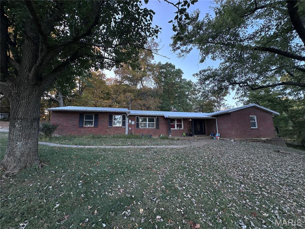 Ranch-style home featuring a front lawn and brick siding