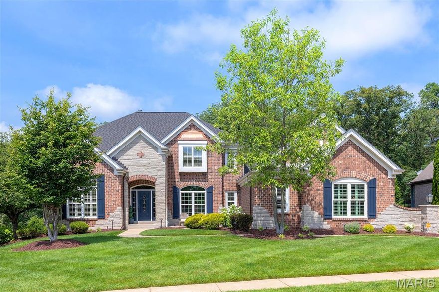 This spectacular brick & stone 1.5 Sty from award-winning Cross Homes features an open floor plan with variable width hardwoods, soaring ceilings, designer lighting, detailed trim work & arched entryways. Impressive hardwood entry foyer leads to formal dining room and stunning 2-sty great room with dramatic wall of windows.  Designer kitchen with granite countertops, 42” white cabinetry, KitchenAid appliances, butler’s pantry & 6’ center island adjoins light-filled breakfast room & exceptionally large coffered hearth room with wide bay window & floor-to-ceiling stone fireplace. Primary bedroom suite with luxury bath & incredible walk-in closet with 5' island offers an appealing retreat. Oak staircase accesses 3 additional bedrooms, 1 with ensuite bath & 2 with Jack n’ Jill bath. Lower Level entertainment space with wide plank hardwood flooring includes recreation room with stacked stone fireplace, game room with bar & media room plus fitness room, craft room, 5th bedroom & full bath. Situated on a .9-acre lot with trex-deck, covered outdoor living space, freeform pool & hot tub, surrounded by landscaped gardens.
