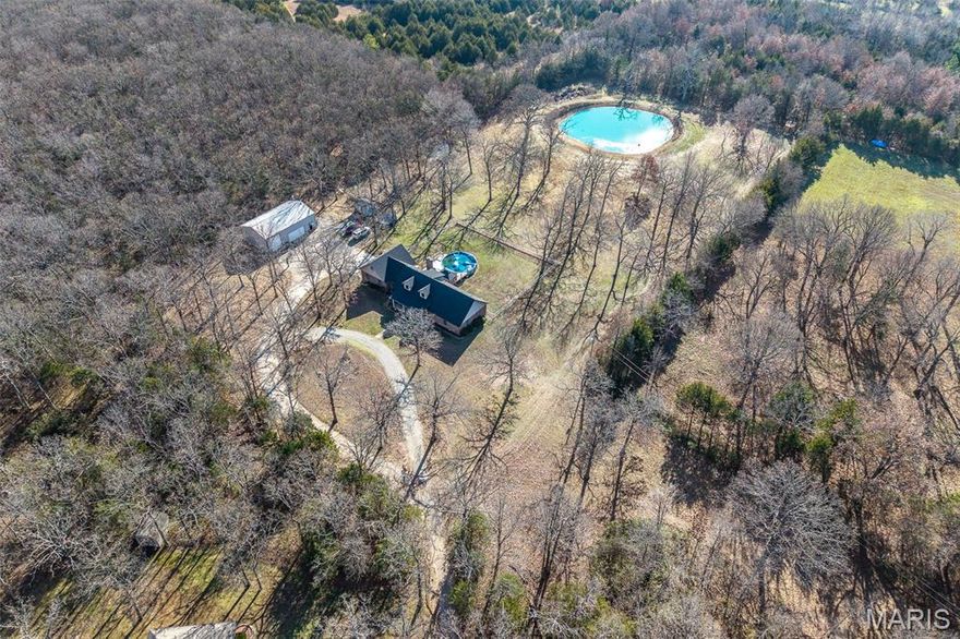 Spacious, Secluded, and Stunning! There truly is no home on the market quite like this one! Perfectly positioned just 5 minutes from town, this spacious and secluded property offers the rare combination of acreage, privacy, and exceptional amenities. Situated on 6.52 acres of beautiful, flat land with mature shade trees, a fully stocked pond, fenced backyard, and circle drive, this 2,960 sq ft home features 5 bedrooms, 3 full bathrooms, plus an additional room ideal for an office or potential 6th bedroom. The updated eat-in kitchen showcases granite countertops, stylish backsplash, upgraded cabinetry, stainless steel appliances, and an oversized walk-in pantry the size of a bedroom. Hardwood floors and a cozy wood-burning fireplace highlight the living room, while the expansive primary suite impresses with hardwood flooring, a large walk-in closet, and a spa-like bath featuring double vanities, a whirlpool tub, and separate walk-in shower. All bathrooms have been updated and the 4 guest bedrooms are spacious and on the 2nd level. Outdoor amenities are equally impressive with a newly built pool deck and above-ground pool, plus a 30x48 insulated shop with concrete floors, electric, overhead doors, and a functioning hair salon—perfect as a hobby space or ultimate she-shed. If you’re searching for space, privacy, and incredible features both inside and out, this property checks every box!