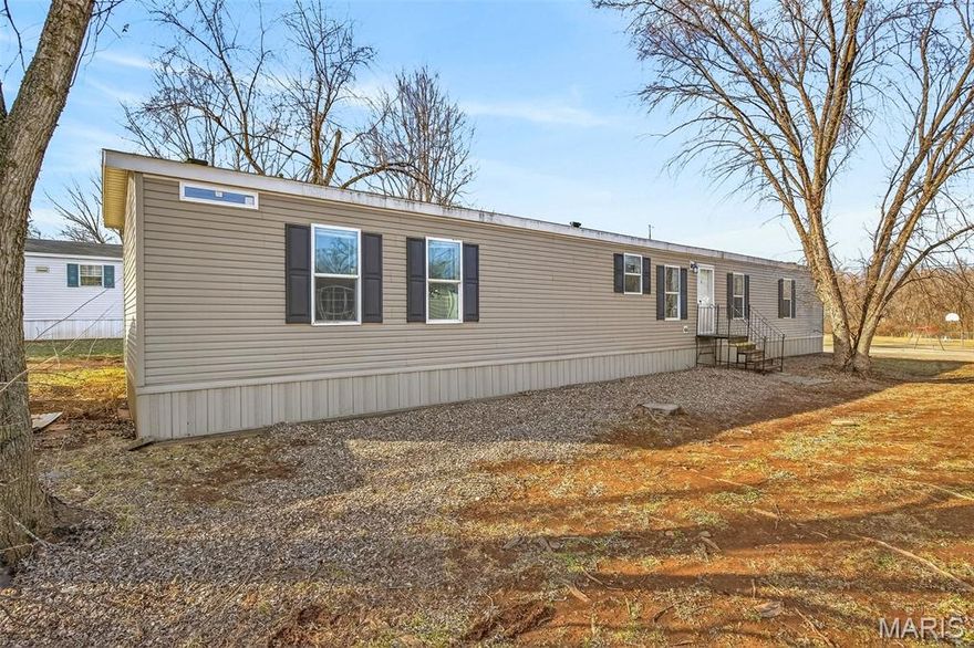 Spacious 4-bedroom manufactured home offering a smart split-bedroom floor plan for added privacy! The primary suite is situated on one end of the home and features a private bath, while three additional bedrooms and a full bath are located on the opposite end. Enjoy the open-concept layout with a large living room flowing seamlessly into the kitchen and dining area, complete with a built-in coffee bar—perfect for busy mornings or entertaining guests. Step outside to a side deck ideal for relaxing or grilling, plus a small storage building in the backyard for extra space. Conveniently located directly across the street from a city park, this home offers both comfort and a great location!