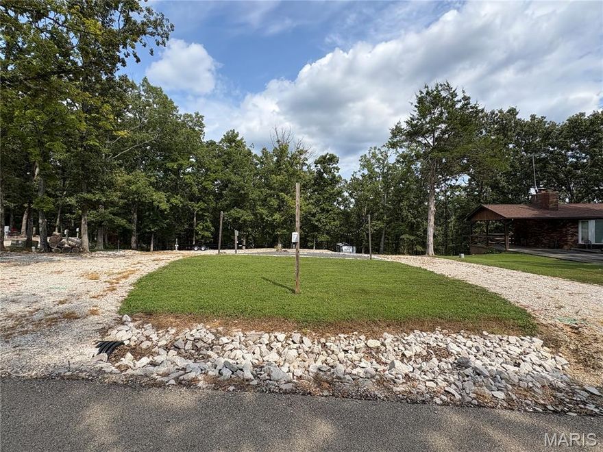 Located just up the street from the community pool, meeting room, marina and playground, this build or camp by permit lot has everything you need for the perfect getaway. This lot offers over a half acre of space, allowing plenty of area for you and a co-owner or guest. This lot features 3 separate 30 amp and 50 amp camper receptacles, along with several convenience receptacles throughout the lot. There are 3 separate sewer connections and 2 water hydrants as well. Enjoy making memories with friends and family while gathered under the string lights and roasting smores around the firepit. Or if you're looking for something a little more private, you and your sweetie can enjoy time alone around the firepit at the lower terraced area, surrounded by trees. This more private area was recently improved with a retaining wall, safety railing, firepit and picnic table. This lot really has it all and is ready for new owners to enjoy all the amenities that Lake Perry has to offer including a 200+ acre lake for fishing, kayaking, boating and swimming, beaches, community pool, gathering place, picnic area, playgrounds, bath houses, laundry facilities and so much more.