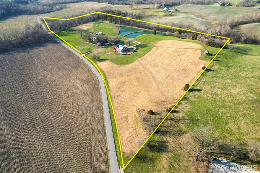 15226 Boone Monument Road, Marthasville, MO 63357

$1,850,000 | 32+/- Acres | Historic Event Venue & Private Estate  

This one-of-a-kind 32-acre property offers a rare opportunity to own a large family estate, turnkey event venue, income-producing retreat, and historically significant property in the heart of Missouri wine country. Rich in heritage and thoughtfully modernized, Boone Monument Village seamlessly blends 19th-century craftsmanship with today's lifestyle and revenue potential.

At the heart of the property is the iconic Main Barn, originally constructed in the 1860s and expanded in 2017, offering approximately 4,000+/- sq ft of flexible indoor and outdoor event space. The grand event hall features vaulted ceilings, exposed beams, a floor-to-ceiling stone fireplace, elegant chandeliers, and multiple French doors that open to a spacious concrete patio complete with built-in firepit and wet bar - ideal for weddings, corporate events, and private gatherings.

The commercial-grade kitchen supports full-scale catering, and ADA-compliant restrooms ensure accessibility. With minimal modifications, the barn can be transformed into a stunning barndominium residence, offering expansive living areas, a primary suite, office overlooking the lake, and potential for additional bedrooms, baths, and garage space.

Equestrian & Land Features
The gently rolling 32+/- acres are well-suited for equestrian use, hobby farming, or recreational enjoyment. The property offers:

Open pasture areas ideal for horses or livestock. Ample space for future paddocks, riding arena, or barn expansion. Existing outbuildings adaptable for tack rooms, equipment storage, or stabling. Scenic riding potential throughout the property's natural landscape. Reliable water access with a stocked 3-acre pond, perfect for both livestock and leisure.

Whether for personal equestrian use or as an added amenity to enhance guest experiences, the land provides versatility and long-term value.

Historic Village & Guest Accommodations
This remarkable property includes a curated collection of restored historic structures, creating a true village setting:

- Main House (Dickhouse Manor, 1863, restored 2014) – 1,785+/- sq ft, 2 bed, 2 bath 

- Schoolhouse (Deveraux, 1843, rebuilt 2012, renovated in 2025)

- Two Log Cabins (Bryan 1799 & Mellein 1853)

- Stone Cabin (Alfermann Smokehouse, 1869, rebuilt 2015)

- Buggy Barn, wash house, lean-to, nature shed, multiple gathering spaces, one tipi with fully insulated HVAC, and two stage coach wagons.

Each structure is equipped with modern utilities while preserving its original character - ideal for overnight accommodations, retreats, or expanded event use.

Historical Significance
Adding to its legacy, the property is located near the final resting place of American pioneer Daniel Boone, one of the most influential figures in westward expansion. The presence of the Boone family cemetery on or near the property grounds provides a rare and meaningful connection to early American history, enhancing both its cultural significance and storytelling appeal for guests and visitors.

Infrastructure & Setting
The property features a gated entrance, gravel drive, and a 20,000-gallon septic system, supporting both residential living and commercial operations. Mature trees, rolling terrain, and thoughtful landscaping create a private, park-like setting just minutes from I-64 and the surrounding wine trail.