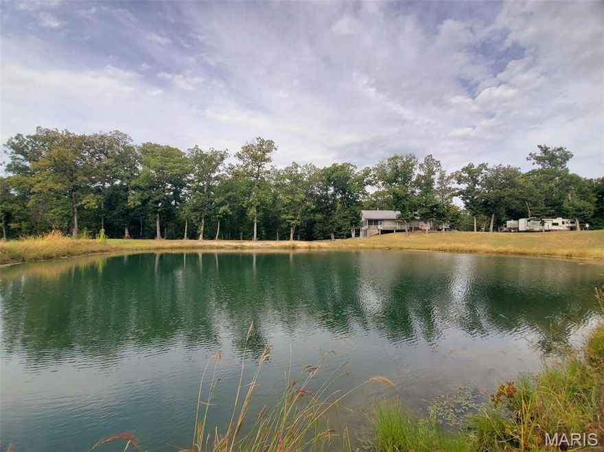 Here's your getaway - over 3,000 finished sq ft in this 5-bed, 3.5-bath home with an open floor plan, woodburning fireplace, granite counters, master suite, finished basement with living quarters and a sprawling screened-in back deck overlooking the stocked lake and timber surrounding the property. This is truly a one-of-a-kind opportunity - this low-maintenance home has been very well-kept and offers stunning surroundings. Inside you'll appreciate the high-end finishes, the attached garage and full basement complete with living quarters that walks out to the covered back patio. The stocked pond (crappie, bluegill, bass & yellow perch) offers the perfect spot to enjoy fall evenings, and an in-ground salt pool is the place to be on summer days. Also included on this surveyed 39.9 acre tract are 2 cabins new in 2018: each 2-bed, 1-bath, fully furnished with covered front porches and metal exterior. Along with the 11 full RV hookups (water, electric, sewer), and 1-partial hookup, this could also be a turnkey investment property. Surrounded by oak timber with established food plot, this is prime hunting in an area known for whitetails & turkeys. With timber running clear to the south property line, there are also gorgeous building sites with access from St. Patrick Trl. With this location the rental income stays steady - located on the edge of scenic Lake of the Oaks, this is close to many public hunting/fishing points and a quick 23-mi drive to Keokuk, IA or 33-mi to Quincy, IL.