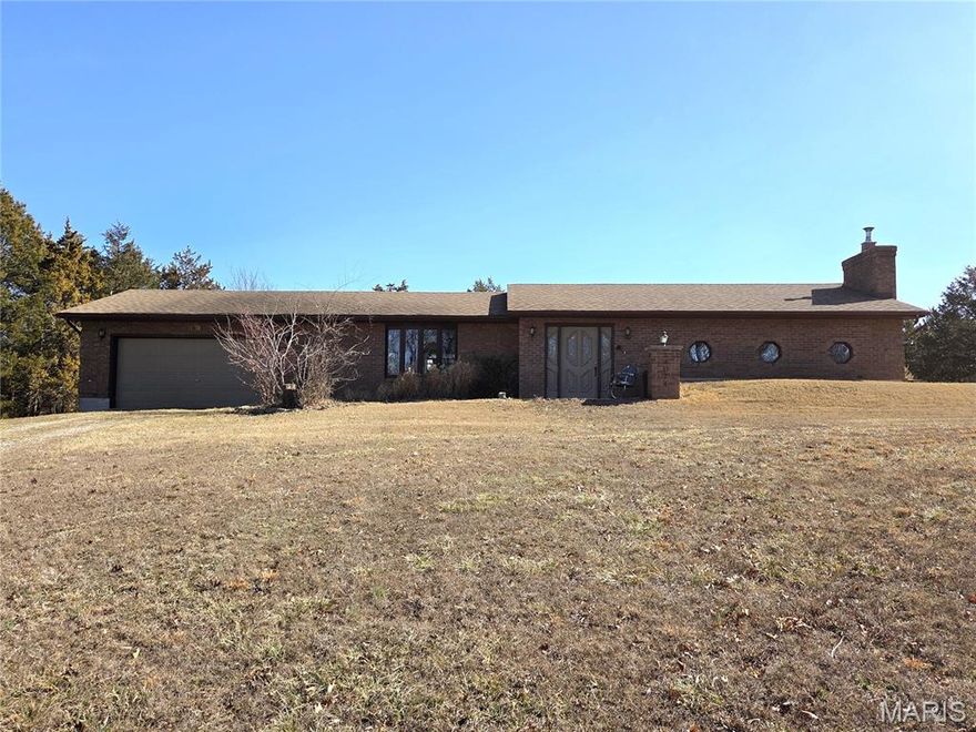 Looking for a private get away setting.  This great brick home on 7.14/- acres has the privacy you are looking for and more.  Large living room with full wall brick fireplace that has a wood insert in that will heat the whole home.  Large open floor plan with hard wood flooring, entry area and separate dining room with bay window.  The kitchen has ceramic tile flooring and offers a breakfast island, plenty of counter space, oversized 3 chamber sink, garden window, dishwasher, electric range with cook top and microwave.   The breakfast area has oversized entry door with side panels that will open for ventilation and walks to an oversized porch/patio.  Full bath was remodeled with a custom tile step in shower, single vanity and linen closet with tile flooring.   Large utility room with laundry hook ups.  One bedroom offers a wall full of closets, carpeting and 3 windows.  The second bedroom has carpeting and custom built-in shelving.   There is a 2-car garage with side man door, windows and slop sink.  Enjoy your private back yard with oversized patio/porch and hook up for hot tub.  This home sits on 11.5 +/- acres, featuring woods that could be cleared and some pasture that can be reclaimed.  There is partial fencing on part of the land and could be closed up quickly for livestock.  A small spring that could offer water for your animals, a small equipment shed and so many possibilities.  There are no restrictions on this land and no association fees.  Come take a look at all the possibilities to make it your own.  Adjoining 4 ac +/-  lot is also available.