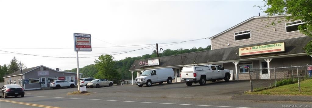 Derby commercial strip with Mattie's Deli and Catering, neighboring storefronts, and parked vehicles.