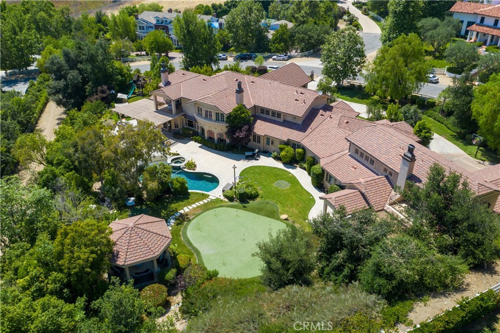 Remarkable celebrity owned entertainer’s estate located in the exclusive Ashley Ridge section of guard gated Hidden Hills. Set on a sweeping corner lot with 1.4 acres of manicured grounds, this property also boasts stunning mountain & pastoral views. Secluded property with entrance featuring porte-cochère and parking for 20+ cars, plus garage parking for 5. Grand 2-story entry with dual curved staircases framing central living room with new wood floors & fireplace; family room with large wet bar opens to covered patios; formal dining room leads to true chef’s kitchen featuring 2 walk-in pantries, 2 sets of Sub Zero refrigerators, & breakfast room; 14-seat movie theater with wet bar; billiard room; gym with sauna; unbelievable office/library with full kitchen, wet bar, aquarium, built-in cigar humidor, & 2 fireplaces; plus a temperature controlled wine storage room. There are 3 en-suite bedrooms downstairs & 3 upstairs. The master suite has 3 walk-in closets, fireplace, patio deck overlooking the yard & surrounding vistas, & brand new remodeled master bath with double vanities, walk-in steam shower, & separate spa tub. The backyard is truly paradise featuring beach entry pool & spa with waterfall, 3 covered patios, BBQ center, putting green, gazebo, & mature landscaping with rolling lawns. There is a separate 1+1 guest house with private access featuring full kitchen & family room. A rare combination of spectacular craftsmanship, incredible amenities, & the ultimate privacy.