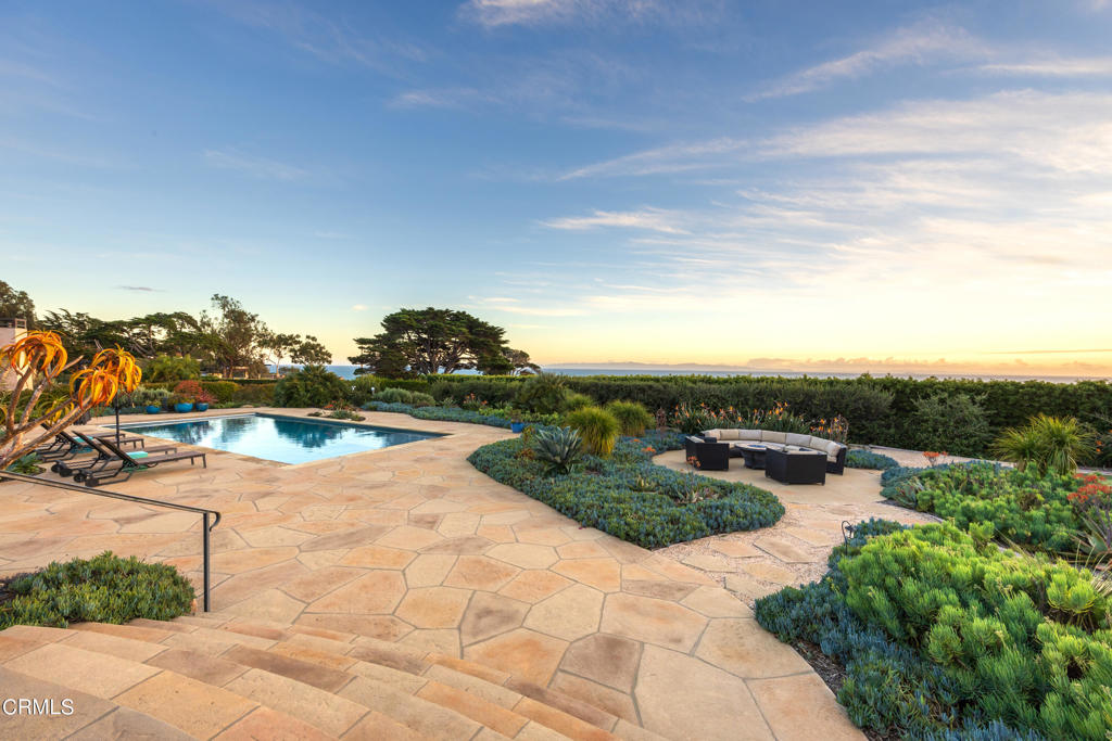Perched on a scenic one-acre enclave just beyond the borders of Hope Ranch,this remarkable estate offers a panorama of awe-inspiring ocean vistas & distant island horizons.Crafted as a year-round retreat, the resort-style amenities are tailored for seamless indoor/outdoor entertainment & relaxation.An expansive fireside loggia beckons w/commanding coastal views,while a sparkling pool invites leisurely dips, complete w/a Baja bench thoughtfully equipped for shaded lounging.Adjacent, a rejuvenating spa cascades w/tranquil water features.A freestanding stone bathroom w/an invigorating outdoor shower invites you to indulge in a moment of tranquility as you wash away the beach sand,preparing for a refreshing dip in the pool.Immerse yourself in the seamless harmony of nature & luxury,where every detail is designed to enhance your relaxation & enjoyment.For culinary enthusiasts,the ultimate gourmet kitchen awaits,seamlessly blending luxury & functionality.A Butler's pantry,complete w/a wine cellar, stands ready to elevate every occasion.A gracious dining room,capable of hosting esteemed gatherings, adjoins this grandeur.Within the sprawling Great Room,a grand corner fireplace anchors the space, radiating warmth & elegance.While floor to ceiling glass doors that retreat into the walls open to the loggia blurring the boundaries between inside & outside & creating a harmonious flow that celebrates the beauty of open-air living.Retreat to the primary suite,where a cozy fire-lit sitting area invites moments of quiet reflection.Luxuriate in the soaking jet tub within the opulent bath,or revel in the convenience of a walk-in closet designed for two.Outside,a private covered patio offers a front-row seat to breathtaking sunsets,a daily spectacle to behold.Originally conceived as a 4-bedroom sanctuary,recent redesigns have transformed a guest wing into a permitted ADU,complete w/its own entrance & fully equipped kitchen, offering unparalleled flexibility & privacy for residents & guests alike.A gated motor court,flanked by a 3-car garage,ensures ample parking for residents & visitors.Wander through the lush grounds,where a boutique orchard promises fresh fruit,raised garden beds offer seasonal delights & a verdant wall of berries delights the senses.Find solace amid the flourishing succulent garden, where hummingbirds & bees dance amongst vibrant blossoms,completing this idyllic coastal sanctuary.Uninterrupted ocean views visible from nearly every vantage point.