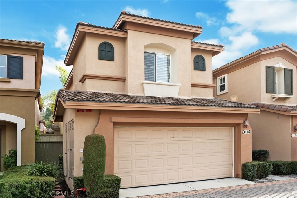 Beautiful unit in desirable Milano community shows like a model home with warm and custom paint throughout. Two master suites are upstairs along with the laundry closet. The master has a walk-in closet and a 2nd custom closet with plenty of storage. Soaking tub and shower. A second suite overlooking the front neighborhood, upgrades, custom two toned paint, clean and custom wall to wall carpet. First level showcases a light and bright open floor plan with white shutters, eating area, 1/2 bath, understairs storage, and cozy fireplace. Attached side by side double 2 car garage with custom storage cabinets. The kitchen has a breakfast bar, Spanish tile, stainless dishwasher, and 4 burner black stove, oven, & microwave. Finished off with crown molding, white shutters, recessed lights, and modern chandelier. The family room slider doors lead to the serene, extra large back yard, plus side yard, tranquil water fountain, and patio. BBQ area, built in planters, stamped cement and stone work. Entertain your friends and family. Centrally located near Soka University, Aliso Viejo shopping center, parks, theaters, and schools. Move in ready. This is one you must see today!