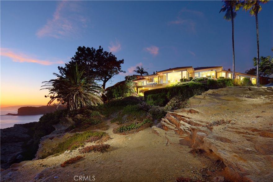 Rarely does a property of this magnitude present itself on the market. A custom ocean-view estate where artistry and nature unite on a blufftop promontory towering over the ocean. A welcoming home that is part luxury, part beauty, and 100% Laguna Beach. Enjoy views that encompass Dana Point, Catalina Island, colorful sunsets, breaking waves, and twinkling evening lights are viewed from most indoor and outdoor living areas at the estate. Located at the end of a private cul-de-sac in South Laguna’s gated Three Arch Bay, the appx. 2.15-acre property encompasses the bluff and part of the beach below. Custom hand-carved mahogany garage doors and a matching entry gate enrich curb appeal, and a private courtyard with Inca Gold natural stone welcomes all with a pool with water feature, electric cover and massaging jets; a built-in  Twin Eagles BBQ bar and Salamangrill and retractable Sunbrella awning; two fire pits and outdoor shower; a full outdoor bath; Bromic heater; and bespoke art from Laguna’s renowned Marlo Bartels. Floor-to-ceiling windows, glass doors, and sliders from Germany’s NanaWall unite exterior spaces with a fabulous interior, where immediate ocean views are experienced upon entry. Main living areas comprise a custom walk-in wet bar with ice-effect glasswork, handmade African movingui cabinetry, a see-through fireplace, a grand dining room that opens to the pool, and a family room with access to an outdoor view deck. The kitchen is as beautiful as it is functional thanks to an island with Brazilian granite top, custom aluminum-finished cabinetry crafted by Bulthaup in Germany, two built-in Miele refrigerators, and a suite of Gaggenau appliances. Blue Bahia and Blue Pearl Granite shine in the primary suite, and select secondary baths reveal Keuco vanities and mirrors. The lower-level theater is accessed by a Garaventa lift and features state-of-the-art A/V equipment. A garage with lift accommodates four cars, a driveway that can fit up three cars, and a Kohler gas backup generator, Lutron lighting, Elan audio, an aluminum roof by Future Roof Systems of Canada, fast water-heating systems, and a 500-gallon whole-home reverse-osmosis system are included.