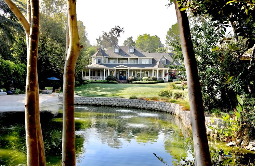 Gracefully sited on nearly one acre with a spring-fed lake, this spectacular Stoddard/Finton home is situated behind gates and on a quiet cul-de-sac. Completely updated, the home's setting feels as if you have left the city. With every luxury imaginable, the floor plan offers gracious living and entertaining spaces. The main level features the formal living/dining rooms, games room, wet bar, chef's kitchen open to the large family room, 2 fire places, butler's pantry, main-floor suite, powder room, and a direct access custom 5-car garage perfect for a car enthusiast. The large wrap-around front porch looks over the sprawling yard, pool, spa, guest house and private lake with beach and firepit. In the backyard are the outdoor living and dining areas with full kitchen, fireplace, pond and second firepit and spa with a seamless indoor/outdoor flow ideal for entertaining. On the second floor there are four suites, a home theater, and laundry room. The large primary suite, with 2 walk-in closets and spa-like bathroom, features a spiral staircase leading to the finished and temperature-controlled attic space, equipped with a home gym, sewing room, craft room, and multiple storage spaces. A separate and independent 1 bed/1 bath guest house sits on the lake front with a large front porch and kitchenette. Completely smarthome integrated with Control4/Sonos system, this spectacular estate maintains and embraces the craftsmanship of a bygone era and must be seen to be fully appreciated.