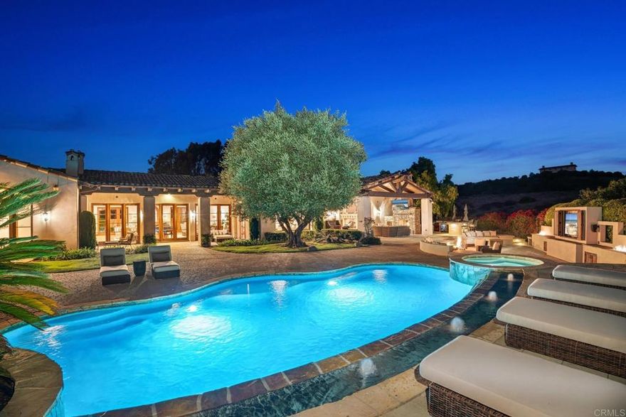 Discover your dream oasis in Santaluz, where breathtaking canyon views and complete privacy create a serene retreat. This stunning home features an outdoor paradise with a sparkling pool and waterfall, a sunken entertaining area with a fire pit and TV, and a fully equipped BBQ island, perfect for summer gatherings. Inside, the open layout boasts a gourmet kitchen with a large pantry and charming breakfast room, a stylish bar with a refrigerated wine cellar, and a bright office space. Enjoy cinematic experiences in the dedicated theater and retreat to oversized en-suite bedrooms, including a luxurious primary suite with a spa-like bathroom and dual closets. Priced to sell, this exceptional property invites you to create unforgettable memories in a lifestyle of luxury and comfort.