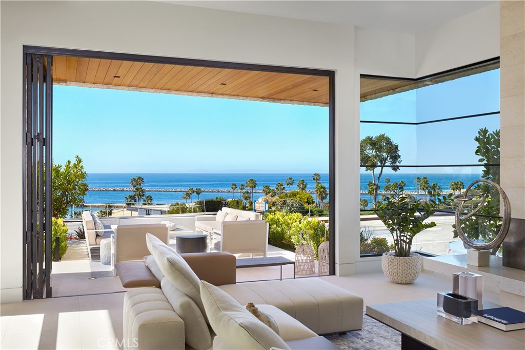 This pristine, new, contemporary-style ocean view residence offers the very best of Corona del Mar. From its perfectly elevated corner position, a panorama unlike any other unfolds before you including the beach and whitewater at Big Corona, the channel entrance, Catalina Island, and colorful sunsets seen throughout the year. Perfectly framed from most every room, the views are dynamic and ever-changing. The residence itself is a masterwork of architectural design; with massive rooms, over height ceilings, walls of glass overlooking the ocean, and exceptional design + detailing. The interiors are effortlessly appealing, and the one-of-kind plan is suitable for living and entertaining with ease. Gallery-like spaces, a two-story wall of hand cut stone, skylights, carefully chosen muted tones + textures, and graphic millwork accents – the work of Nicholson Construction, acclaimed architect Mark Teale, and designer Suzanne Biers Harrington – are a few of the many highlights. The main level includes an oversized great room anchored by two view terraces; one at either end. The kitchen and informal dining share in the views and terrace access. The upper level includes an impressive ocean view master suite with private sitting area + terrace, an informal media room + office, as well as two additional bedroom suites. Offering the perfect combination of location, views, design and construction, this is the most compelling offering seen in the village in a decade.