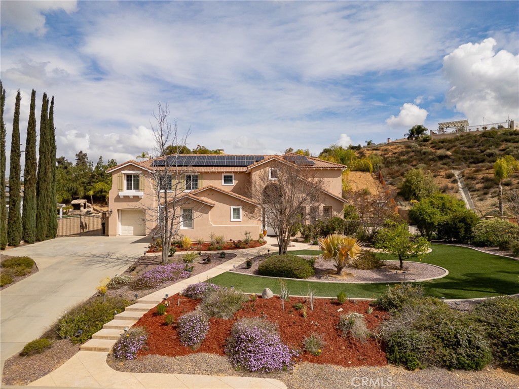 Stunning Mediterranean home on over an acre of land! Enter into the two-story foyer with designer stone flooring, to the large formal living room/dining room combination with two-story ceilings and plantation shutters. To the most amazing gourmet kitchen/family room you will ever find! The kitchen features the most high-end details from custom dark wood cabinetry and extra-large island to all of the appliances: 48-inch 8 burner Wolf range with double ovens and Wolf hood, two 36-inch Sub Zero’s each with an ice maker, a Wine Enthusiast 300 bottle wine refrigerator, and Miele Dishwasher. The countertops and sink in the kitchen are custom Taj Mahal natural quartzite. There is the most charming round eat-in breakfast nook area in the kitchen. The attached family room has stone flooring and wall detail with modern fireplace with access to the large rear yard! On the first floor is an ensuite bedroom and beautiful custom built-in cherrywood office. On the second floor is the large primary suite with views of the rear yard, sitting area and cozy fireplace. The Primary luxurious spa like bathroom has all new dark wood cabinetry with a built-in vanity and dual vessel sinks with white marble countertops, separate beautifully tiled walk-in shower with dual showerheads and separate tub, walk-in custom cedar lined closet. Upstairs there is also a large loft space, two additional good size bedrooms and a remodeled bathroom with dual sinks, white marble countertops with interior lighting and a separate walk-in shower area. The rear yard is expansive with a beautiful wooden cabana with a television and electric fireplace, built-in BBQ island with gas burner, sink and marble countertops. There is tons of flat usable outdoor space with lots of fruit trees, grassy turf so it is green all year and a sport/basketball court. Room for RV behind gates. Paid for solar with LG Battery. Reverse Osmosis Alkaline water filters and water softening system.