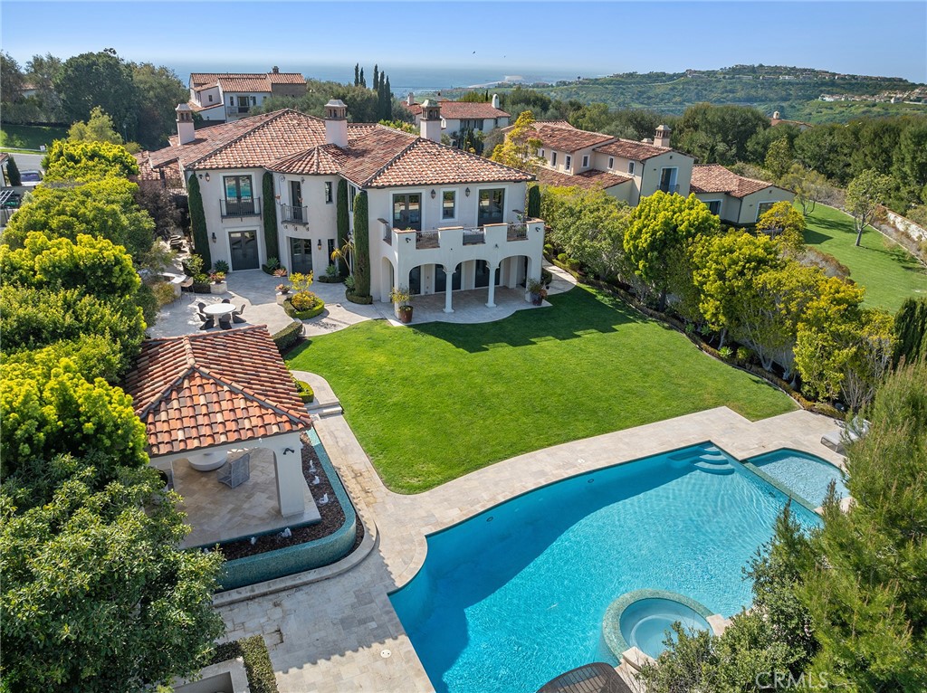 Indulge in the serenity of elevated Newport Coast living at this exceptionally private and luxurious estate on an oversized lot behind the guarded entry gates of Crystal Cove. Located near the top of the exclusive enclave, the grand residence is nestled on flat, sprawling grounds that extend more than one-half acre and welcome all with a gated entry courtyard featuring formal manicured gardens. Interiors are spectacular in both size and style, offering nearly 7,448 square feet of refined living space. Six ensuite bedrooms and eight opulent baths ensure unmatched comfort, including a main-level bedroom, and a detached casita that hosts a private bath and walk-in closet. A stately entrance leads to large formal living and dining rooms, each featuring French doors that open to picturesque patios, tranquil fountains and lush, expansive grounds. Imagine the memories you will create in these extraordinary spaces with the people who mean so much to you. Casual times together are easily enjoyed in a great room that offers access to the oversized backyard that features a pool, fountains, fine hardscaping, mature and manicured landscaping, and ample entertaining spaces to enjoy with loved ones in complete privacy. The ultimate in culinary-focused environments awaits in the estate’s two kitchens–one reserved for catering special events, and the other open to living areas and boasting a large island, circular nook, walk-in pantry and top-of-the-line appliances. A spacious home office on the main level, a versatile loft and a generous bonus room lend flexibility to the residence, which is adorned with hardwood flooring and custom stone and tilework throughout. Juliet balconies complement several second-floor rooms, while the grand primary suite reveals a large deck overlooking the backyard and the rolling hills of Crystal Cove State Park. Enjoy a fireplace, a boutique-style walk-in closet with illuminated custom built-ins, and a sublime primary bath with deck access. Truly an oasis, the estate’s grounds are embellished with resort-level amenities that include numerous fountains, a pool with spa, an entertainment pavilion, built-in BBQ bar, and a spacious lawn for parties, playtime and so much more. Just moments to world class shopping, dining, and beach access, as well as Newport Beach and Laguna Beach are minutes away. Your opportunity to enjoy a residence of enduring distinction in a setting without compare has arrived.