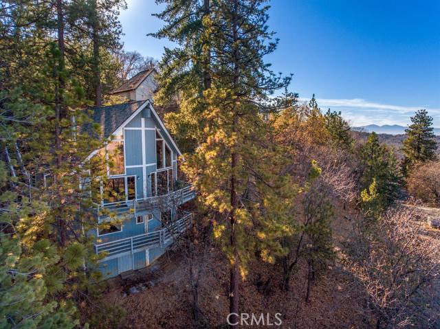 Investor opportunity with lake rights! Mid-century style but built in '82, with all the post '78 upgrades! Enter on main level with soaring open-beamed ceilings, towering fireplace, handsome wood-encased walls, open kitchen, and a large outdoor deck. Other main level features include the ever sought-after open floor plan, two-story wall of glass, and dedicated laundry room. Upstairs you'll find a large loft where you'll retire to views of faraway city lights, and rise to sweeping vistas of the Mojave desert. Downstairs you'll find two bedrooms, a full bathroom, and a private covered balcony. Sure, there are things to be done here but you'll find few homes that can compete at this price! Bring an offer!