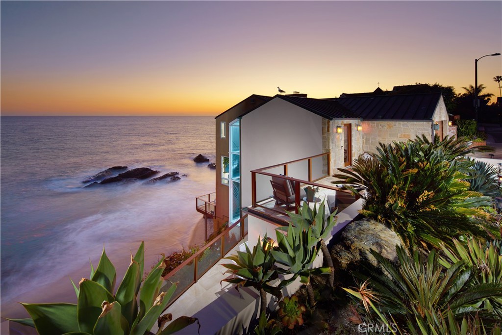 Beachfront living without compare awaits at this extraordinary Woods Cove home in Laguna Beach. Extending three levels over the sand, the extra bright and open design is embellished with unparalleled views of the cove, breaking waves, the Pacific Ocean, towering bluffs and dramatic sunsets. A gated ocean-view terrace provides sublime curb appeal and leads the way to a lofty foyer with whitewater views and a glass-enclosed spiral staircase descending to lower floors. This level is home to three of the residence’s five bedrooms, with one featuring a window seat and the others overlooking the beach. Follow the stairs down to the main level and discover a wide-open space flooded with natural light and ocean views, with one deck offering a built-in BBQ and another that is just right for evening cocktails at sunset. In fact all combined, outdoor balcony spaces comprise nearly 1,000 square feet. A family room and a spacious dining room are perfect for entertaining, and the bonus room offers versatility and an abundance of built-in cabinetry and shelving. On-trend design is displayed in the kitchen, where an oversized two-tiered island complements white Shaker cabinetry with glass uppers, a wine cooler, built-in refrigerator and a pro-grade 48" Thermador range. The lowest floor is reserved for a primary suite that indulges the senses with ocean views, sea breezes, an over-the-sand sun deck, and a sumptuous bath. Approximately 2,960 square feet, the home’s appeal is further enhanced with wood and tile flooring, crown molding, skylights, floor-to-ceiling windows, vaulted ceilings, an attached two-car garage with epoxy flooring, and dual air-conditioning systems. Stroll along the sands of Woods Cove or head out for a day of shopping and evening of dining at Laguna Beach’s countless stores and restaurants.