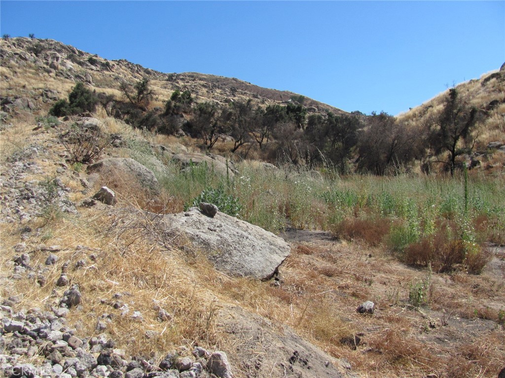 Two parcels totaling 81 +/- acres on Gibbel Road in Hemet. The terrain is hilly with rock, trees and riparian areas