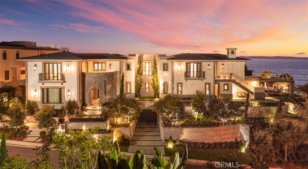 Crowning one of the finest homesites within Dana Point’s guard-gated The Strand at Headlands enclave, this brand-new custom ocean-view estate is without compare in Orange County. No expense has been spared on the 13,777-s.f. masterpiece, which combines private, fully appointed grounds and a 9-bedroom, 12-bath floorplan into one unrivaled compound. The home showcases the talents of award-winning architect Chris Light and Hawk & Co. interior design. Multiple sets of disappearing glass doors open most living areas to phenomenal ocean and Catalina views from its top two levels, with the lowest level offering underwater views of the vanishing-edge pool. Contemporary and traditional style unites to create and air of chic sophistication throughout, including a 3-level foyer with floor-to-ceiling window, a custom chandelier and dramatic circular staircase. This appealing ambiance continues in a great room, a dining room that seats 12 or more, and a lower level with game room, theater and a bar with kitchen. The main-level kitchen hosts two islands and a hidden catering kitchen, and an office is fully appointed. Serene Pacific vistas enrich a master suite with extensive wardrobe storage and a sumptuous bath. Only the finest finishes and fixtures are featured, including stone and wood flooring, paneled walls, custom lighting and marble. An elevator serves all levels, and many rooms open to a private courtyard that can be viewed from second-level Juliet balconies. Spacious terraces, a hidden grotto and gorgeous gardens complement a peninsula homesite of nearly 25,167 square feet.