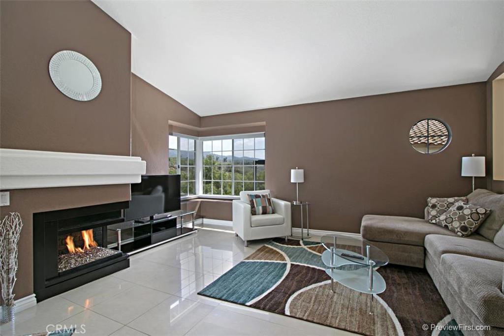Welcome Home to the stunning upper end "Carriage" unit, with spectacular Hills and tree views, located adjacent to prestigious Coto de Caza. This "open floor plan" is ideal for entertaining and features vaulted ceilings, over sized porcelain tile flooring, and designer paint throughout. The updated kitchen has more than ample counter space, recessed lighting and a breakfast bar which opens to the dining area and living room with a fire and ice gas burning fireplace. Large master suite with a ceiling fan and vaulted ceiling. The over sized master bath has dual sinks, recessed lighting, large oval tub/shower and a custom walk-in closet with mirror closet doors. The light and bright guest bedroom is currently being utilized as an office. The second full bath just down the hall. You have direct access from the one car garage, which features built-in storage/work area, and a full size laundry area. Additionally there is a large covered balcony to relax and enjoy the fabulous views. One assigned parking space is conveniently located near the unit. The complex has a sparkling pool and spa and a children's play area. Just steps away from the best Rancho Santa Margarita has to offer including shopping, dining, theater, and Central Park!