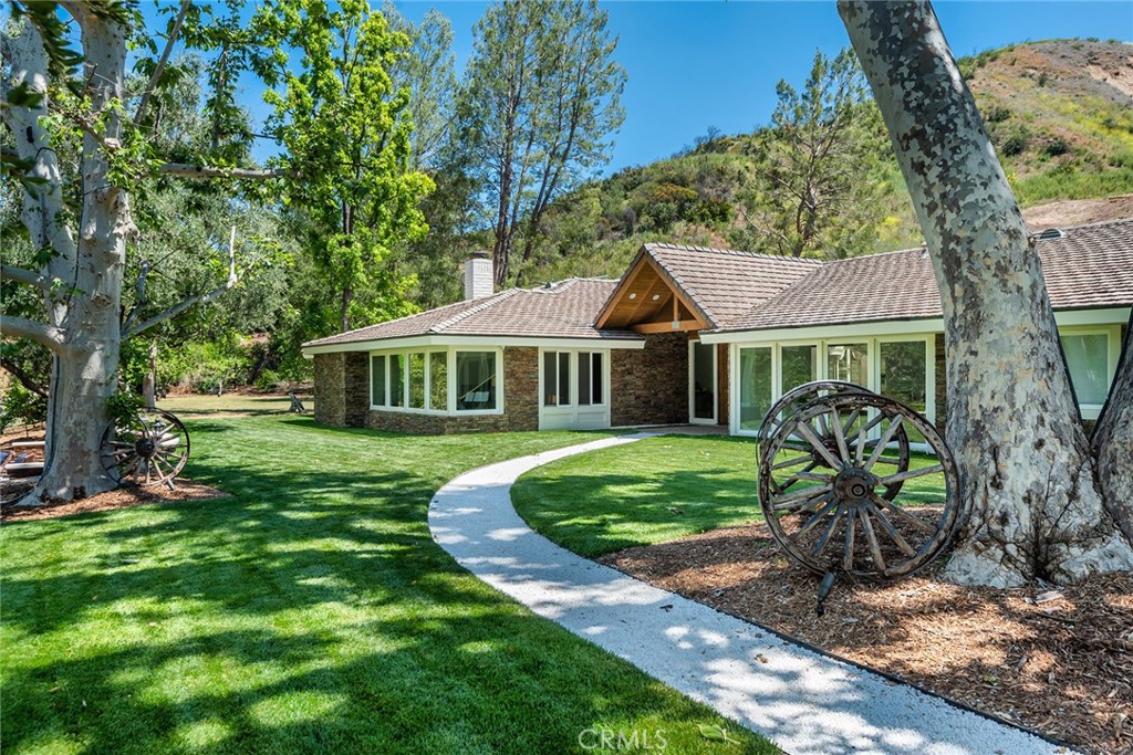 "THE RANCH" at the gated community of Paramount Ranch Estates, is set on 10 ultra private acres and ready for its new owner! This fully updated paradise features a beautiful single story custom estate that spans over 5,400 sq ft of luxury and quality in a sunny, open floor plan. Features include a gourmet, center island chef's kitchen with Viking & Sub-Zero appliances, custom cabinetry, refrigerated wine storage, and granite & butcher block countertops, that flow seamlessly into the breakfast nook and sunroom. There is a large family room with vaulted ceiling & fireplace, formal living & dining rooms, and 5 spacious bedrooms, 6 baths, including the luxurious master suite with fireplace, dual closets, oversized bath with stone counters, soaking tub, and rain shower. Additional home amenities include hickory wood flooring throughout, a smart home system, central vacuum system, water purification system. The resort-like grounds feature a large sparkling pool & spa with waterfall, pergola w/full kitchen & barbecue, pool house with dry sauna & full bath, 6 firepits, your own lighted tennis court & basketball court, mature fruit & shade trees, and garages for 3 cars. The superb equestrian facilities include a recently built, first class 7 stall barn, tack room, full riding arena, multiple turn-outs, and a motorized horse walking facility. This is a rare property with wonderful privacy & amenities, all behind gates, close to shopping, and the nearby beaches of Malibu. Welcome to THE RANCH!