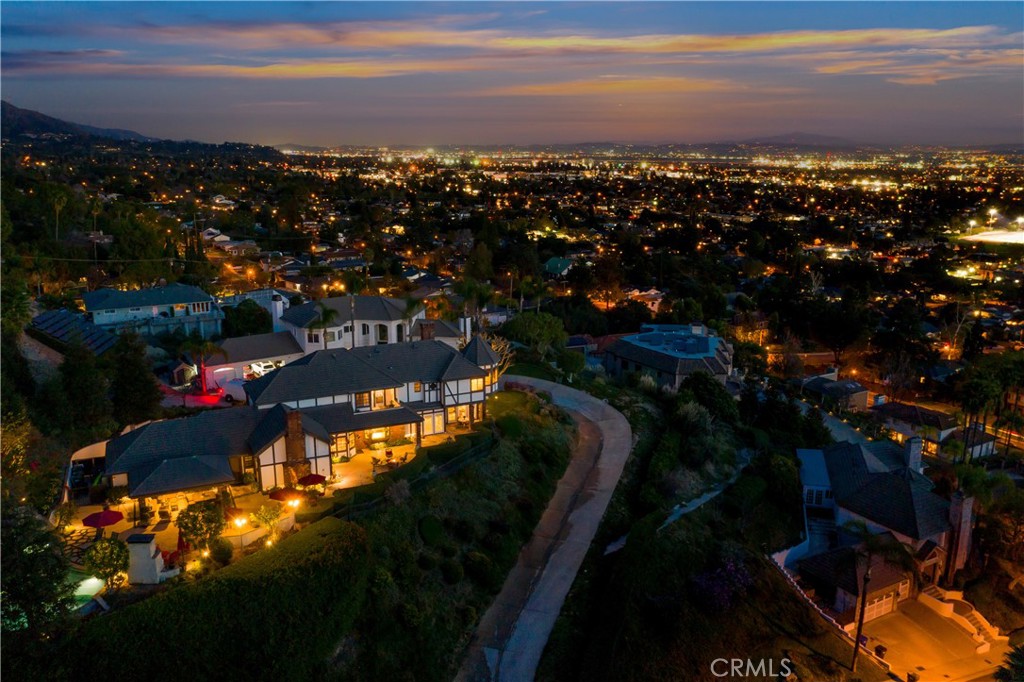 Awe-inspiring views that greet you at nearly every turn in this stunning Monrovia home optimally tucked into the foothills! Immaculately crafted by Mur-Sol Construction, this must-see residence is enviably set on a premium lot in the only gated community in Monrovia. A beautiful facade with a regal double-door welcomes you into the foyer, abundant natural light to accentuate the timeless interior that exudes a welcoming ambiance for anyone who enters.Stunning hardwoods lead you into the family room that sits under impressive vaulted ceilings clad in wood and exposed beams. A soaring brick surround frames your majestic brick-faced fireplace, an ideal spot for cozy evenings. Fall in love with the impeccably designed kitchen that comes with tons of gorgeous cabinetry accentuated by granite countertops gleaming under recessed lighting.High-quality appliances adorn the culinary space. Enjoy the home chef's signature dishes in the elevated dining room under stylish lighting and coffered ceilings. Striking features await you in the 4 bedrooms, including balcony access and a full-length bookshelf. Immerse yourself in the comfort of carpeted flooring across the upper level that hosts a hallway nook before guiding you to the opulent primary suite. Your ultimate retreat reveals a walk-in closet and a chandelier-lit sitting area. Begin the mornings on its private balcony perfectly placed to capture breathtaking vistas. Pamper yourself in the elegant spa-like ensuite showcasing a soaking tub, a double vanity, and a glass-enclosed shower with tasteful tile work. Unwind in the comfort of the cheerful formal living room with views from every window where doors whisk you out to the sunkissed patio with a fire pit to gather around. Outdoor get-togethers are a breeze in the entertainer's dream backyard with spectacular cityscape and mountain panoramas as your backdrop. Whether you're relaxing under ceiling fans on the covered patio or hosting weekend cookouts at the built-in BBQ with a keg, this showstopping abode treats you to endless hours of fun. A waterfall feature lends a soothing vibe to your lustrous infinity-edge pool and spa that's just waiting for you to take a refreshing dip. As a bonus, there's an office whenever you need a space for working from home, an attached 3-car garage, and a laundry room. Here's your chance to live a lifestyle of comfort and leisure, so what are you waiting for? Come for a tour before this phenomenal property slips you by!