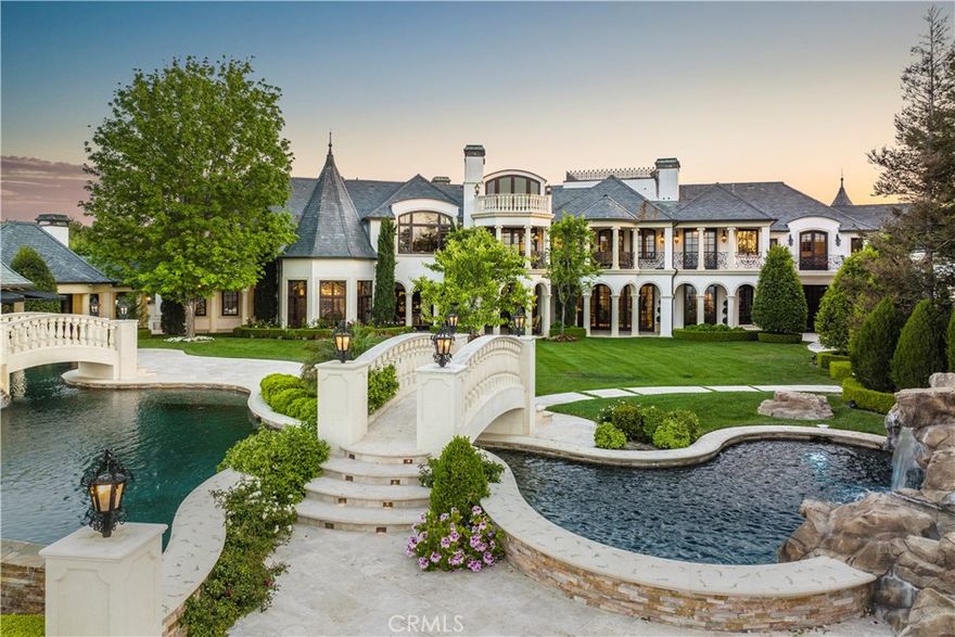 Offered fully furnished, this is easily one of the most exquisite properties in all of Calabasas, this architectural masterpiece of French influence and design is nestled behind the prestigious second gate in The Estates at The Oaks. Sited on over 1.1 acres, and featuring panoramic city and mountain views, it was created by the award-winning architect Richard Drummond Davis, and constructed with the finest materials imported from Europe. Spanning nearly 17,000 square feet of luxury and superb quality, the home features a solid limestone exterior and sits on a sweeping, and very private corner lot. Highlights include a grand entrance with a soaring 30' tall domed ceiling, embellished with detailed French moldings, two floating staircases, a two story formal dining room, an entertainer's gourmet kitchen with spacious breakfast nook, a custom office, and a gorgeous screening room with adjoining bar/lounge. There are seven en suite bedrooms, five with private balconies, highlighted by the gorgeous primary suite that is a world apart with a stunning view both from the bedroom and the all stone bath with oversized octagon steam shower, bathtub surrounded by luxurious honey onyx, and expansive custom closets. Bi-fold doors open to the stellar grounds that feature a sparkling, 110' award winning, infinity edge pool & spa with multiple waterfalls, bridges crafted from Italian limestone, large covered barbecue pavilion with outdoor dining area, guest house, fruit orchard, and mature privacy landscaping, all giving the feel of a luxury retreat experience. Two gated driveways, garages for 6-cars, plus additional off street parking complete the home which awaits the most discerning buyer. There are both long and short property videos linked to the MLS. ***SELLER MAY CARRY A NEW FIRST LOAN AT 4% INTEREST FOR 2 YEARS, FOR A QUALIFIED BUYER.