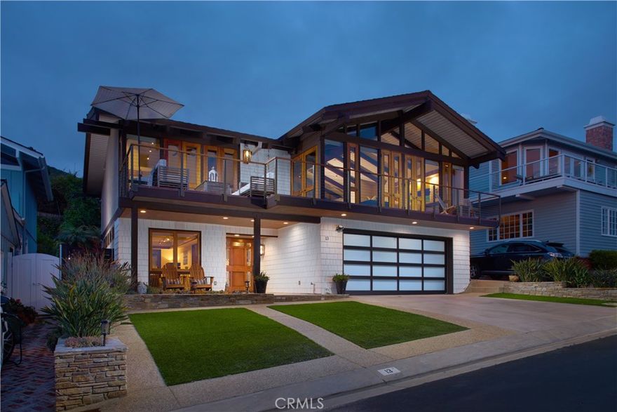 Tucked away in the ever-desirable beachside community of lower Three Arch Bay, this exquisite four-bedroom, three-bathroom retreat showcases the talents of acclaimed architect Chris Abel and embraces sweeping vistas of the Pacific Ocean and Catalina Island. Bathed in abundant natural light, approximately 2,709 square feet of interiors flaunt refined artisanal touches, oak hardwood flooring, remarkable glasswork, rich woodwork and an open floor plan. Upon entry, guests are welcomed by a breathtaking mahogany/stained glass door, warm and welcoming foyer, and executive library resplendent with built-in teak cabinetry and a discreet peek-a-boo ocean view. The remainder of the ground level includes two guest bedrooms, full bath, ample storage closets, fully-equipped laundry room, and direct access to a two-car garage. Epitomizing the laid-back elegance of the Laguna Beach lifestyle, the upstairs main living area is characterized by captivating, west-facing panoramas of the ocean. Warmth exudes from the fireplace in the Great Room which shares a footprint with the recently renovated chef's kitchen, formal and informal dining spaces. The upstairs primary suite offers a personal haven, complete with an inspiring ocean view, walk-in closet, renovated en-suite bath, and direct deck access for peaceful morning or evening solitude. On the same level, a private secondary en-suite bedroom offers guests a luxurious stay. Idyllic for grand-scale entertaining, the inviting deck provides a perfect backdrop for sunset soirées and taking in the ocean breezes. Additional highlights include a newer roof, tankless water heater, newly replumbed and renovated kitchen and baths, dumbwaiter, four additional uncovered guest parking spaces, and French doors providing direct access to the rear patio and yard. Residents of Three Arch Bay enjoy 24-hour guard-gated security, private beach access, community park, clubhouse, and tennis and basketball courts. This remarkable residence truly embodies the quintessential coastal lifestyle.