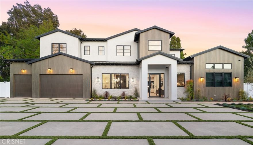This flawlessly imagined 6 bed, 7 bath, 8,027 SF custom farmhouse in prime Encino sits on a flat lot of over 20,000 SF. The 100+ foot long and 27 foot wide driveway that leads to the home allows for effortless parking of all your friends and loved ones while not impeding access. This grand property is complete with a home gym, office, theater, 450 SF guest house with kitchenette and shower, an attached 3 car garage, and solar panels. Inside, the home offers an open floor plan with soaring 12 foot ceilings. The elegant dining room is accompanied by a sleek bar. Adjacent you will find a fully equipped chef’s kitchen with Thermador appliances, wine fridge, two dishwashers, two sinks, pot filler, oak cabinets, quartzite counters, grand kitchen island, additional service bar with double sided seating, and a breakfast nook. The adjoining living room has eye catching beamed ceilings, modern fireplace, and sliding glass pocket doors to the backyard; exceptional for indoor-outdoor living. Atop the grand, glass lined staircase you’ll find well appointed en-suite bedrooms and a master suite fit for royalty. The suite features vaulted ceilings, fireplace, and huge dual walk-in closets. The master bath affords double sinks, soaking tub, shower with 3 shower heads, and balcony overlooking the backyard. The beauty continues outside with a large baja entry pool and Jacuzzi with water spill, sports-court, fire-pit, covered patio, trellis for al fresco dining, and outdoor kitchen with built-in BBQ, fridge, and bar seating. Whatever you desire, this lavish estate will fulfill beyond all measure.