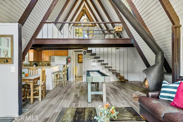 This modified A-frame sits on a spacious, almost level lot. Just a few stairs up to the front door where you are welcomed by a cozy open plan living room with wood burning fireplace that leads out onto a large deck - perfect for enjoying the fresh mountain air on summer evenings. The main living level also includes the dining area, kitchen and master bedroom & bathroom. A slider in the bedroom opens to the fenced backyard. Upstairs is a loft bedroom. Laundry is in the buildup below, with lots of storage space too! Newer windows, flooring and an EV charger are some of the upgrades. Make this vintage mountain cabin your getaway today!