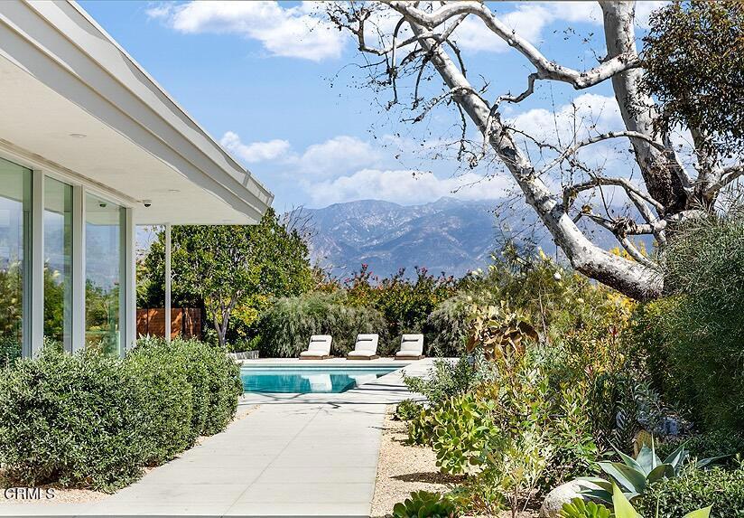 Design wins, simplicity stands out and here, nature is the ultimate inspiration. Designed to maximize the quintessential Southern California lifestyle and sited to benefit from natural light, sweeping vistas and garden views, this mid-century modern home is quiet luxury defined. From the stacked brick facade curving into the entry and living room, to the aggregate bench hearth in the family room amplifying the artistry of terrazzo floors, elegance and welcome are the mantra. Brass inlays score the terrazzo creating symmetry and warmth that crescendos at the copper fireplace hood separating living and dining rooms. An array of carefully curated brass lighting fixtures echo this warm welcoming feeling, carrying it to every room. Designed by Albert Frey disciple Harold B. Zook, meticulously renovated in conjunction with noteworthy Angelenos architect Emily Farnham, interior designer Sarah Sherman Samuel and landscape architects Terremoto, from curb to fence and far beyond the eye is engaged. The kitchen is a refined showpiece where hues of green and grey mingle, pulling leafy landscapes indoors through walls of windows blurring boundaries between indoor and outdoor space. Practical features include large walk-in pantry, high end appliances and dramatic marble island with double-waterfall seating for four, and adjacent large laundry room. A breakfast room, with walls of glass, looks toward Annandale Canyon. Although totally open to a large outdoor patio and canyon garden view, the space feels protected and private; perfect for sleepy morning conversation over coffee or tea. A showcase vestibule separates the primary suite from public and family spaces, with picture windows serving as art walls offering sun drenched built-in sofa seating below blue skylight views. The primary suite turns up the design volume with absolute integration of indoor and outdoor space and artfully simple interior choices with built in headboard, night stand stands and pendant lighting, it is a true retreat. Heated floors and huge walk-in closet are fun and a beautiful spa-like bathroom boasts a splendid canyon view from the soaking tub. The property opens and blossoms here where views of pool, patios, gardens, canyons and mountains conspire to create an ever changing one-of-a-kind experience. Brilliant architecture, design collaboration over generations, and the perfect Pasadena hilltop perch above the Arroyo Seco intersect to create this unicorn experience. There is only one.