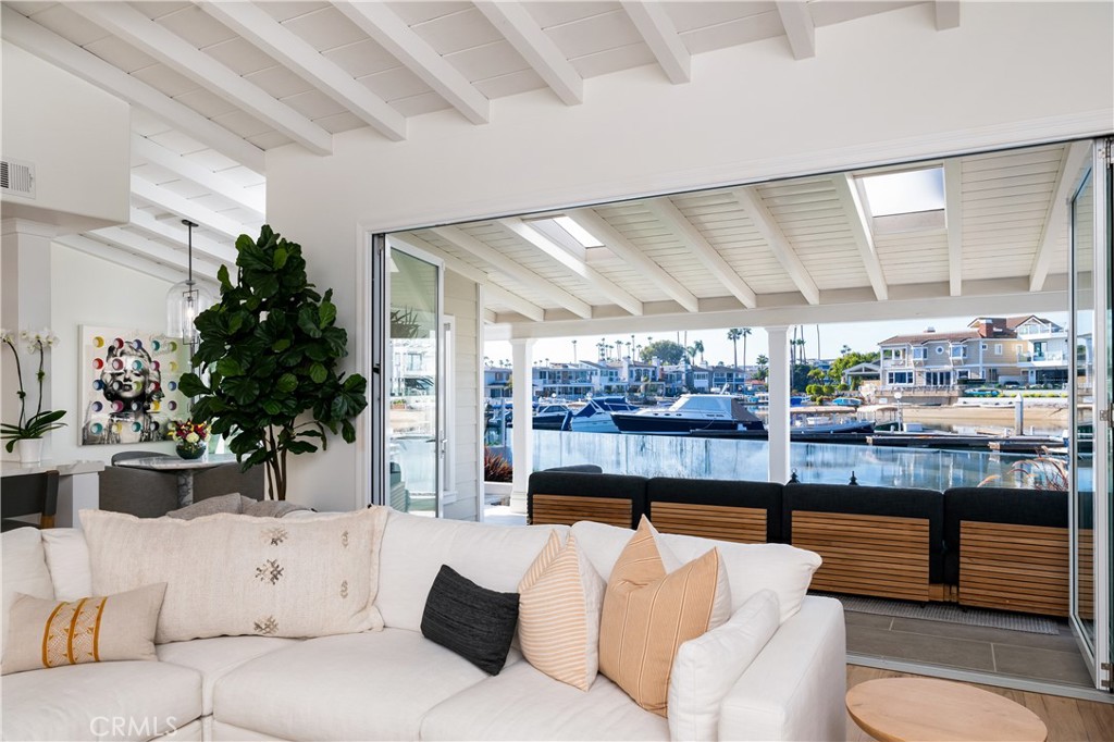 500K Price Improvement! Enjoy the very best of Newport Beach coastal living in this thoughtfully reimagined bay front home offered FULLY FURNISHED, located on a semi-private beach in an exclusive gated area with only 68 homes. With over 38 feet of waterfront, this home also has a private slip to accommodate a vessel of up to 35 feet for boat enthusiasts. This home also offers the rare feature of two bedrooms on the main level, one being a potential primary suite. A private park across the street and tons of parking for guests is yet another rarity in Newport Beach waterfront living.
The open concept is complete with French Oak flooring throughout with beamed ceilings to add to the coastal chic aesthetic. A professional chef's kitchen boasts a large island, quartz countertops, Wolf appliances, and custom lighting and cabinetry. Just off the dining room is a newly built temperature controlled wine room which holds up to 168 bottles of your favorite vino.The interior was designed and furnished by Restoration Hardware.
Exterior was redesigned by landscape architect Ray Morrow Designs and now includes seamless indoor/outdoor living, with La Cantina Bi-fold doors, new patio, stonework, quartzite barbecue, fire pit, custom water features, and hand-crafted exterior lighting.
Upstairs a tranquil primary suite awaits with fireplace and private balcony to take in the sunsets over the bay and watch the boats come in at the end of the day. The en suite bath is complete with oversized walk in closet, marble floors, free standing soaking tub, glass enclosed shower, and dual sinks. Also upstairs are two other bedrooms and full bath with dual sinks and marble flooring. Balcony in front overlooking the park.
Other upgrades in this exceptional property include a Nest system, new garage door, new plumbing, tankless water heater, sump pump, and glass fencing. Come take advantage of all Newport Beach has to offer with award winning schools and world class shopping. One highlight of this enclave is a private pedestrian gate steps away to access Lido Isle and all the fabulous shops and restaurants.Or, take your duffy from your private slip to the Balboa Fun Zone, Lido House Resort, and all the waterfront establishments without having to get in your car and fight traffic!