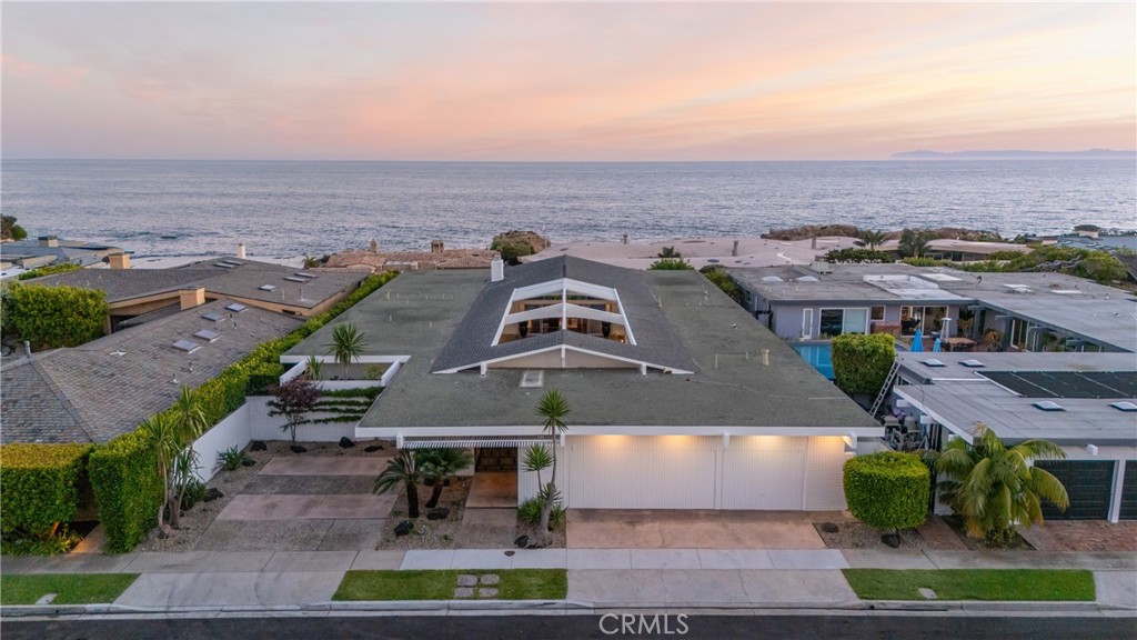 Prominently positioned just one row back from the bluff in the ultra desirable seaside community of Cameo Shores, 4633 Camden Dr is an extraordinary opportunity to own a piece of mid-century architectural brilliance on a rare oversized lot exceeding ~14,000 sqft. Designed far ahead of its time, this 4 bedroom, 5 bathroom, ~3400 Sqft mid-century marvel features a floorplan that maximizes the jaw-dropping views of the Ocean, Catalina Island's rolling cliff-sides, captivating boat activity flowing in & out of the harbor via the mouth of the Newport jetty, white water coastline, and piers stretching up to Palos Verdes. Upon entry, guests are met with breathtaking ocean views in the expansive courtyard, complete with oversized pool, full pool bath, and outdoor entertainers kitchen, offering a serene oasis for living everyday like you’re on vacation and hosting grand scale social gatherings. The main living and dining areas are lined with walls of glass sliders, providing seamless transitions to outdoor spaces and inviting the stunning coastal landscape indoors. The primary suite offers a well appointed retreat with lay-down views, where residence can go to rest at night to the soothing sounds of waves crashing, while large picture windows and sliding doors throughout the home flood the interior with natural light, and showcase dynamic views of the Pacific Ocean's sparkling waters, marine life, & picturesque sunsets year-round, creating the ultimate coastal haven. Adding to the architectural elegance, a unique skylight frames the ceiling of the pool area, reminiscent of a James Turrell Skyscape, enhancing the home's sophisticated design. What makes this opportunity truly special is the potential for customization. The existing home can easily be renovated into a stunning mid-century modern masterpiece, allowing you to enjoy its timeless elegance while planning a future redevelopment into a custom dream estate. Within steps to 3 private gated beach access points and moments from the vibrant Corona del Mar Village, world class shopping, renowned resorts and golf clubs, top schools, Crystal Cove shopping and hiking trails, and John Wayne Airport, 4633 Camden Dr is a unicorn chance to make a piece of coastal excellence your own.